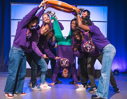 Group of people holding a person doing a handstand