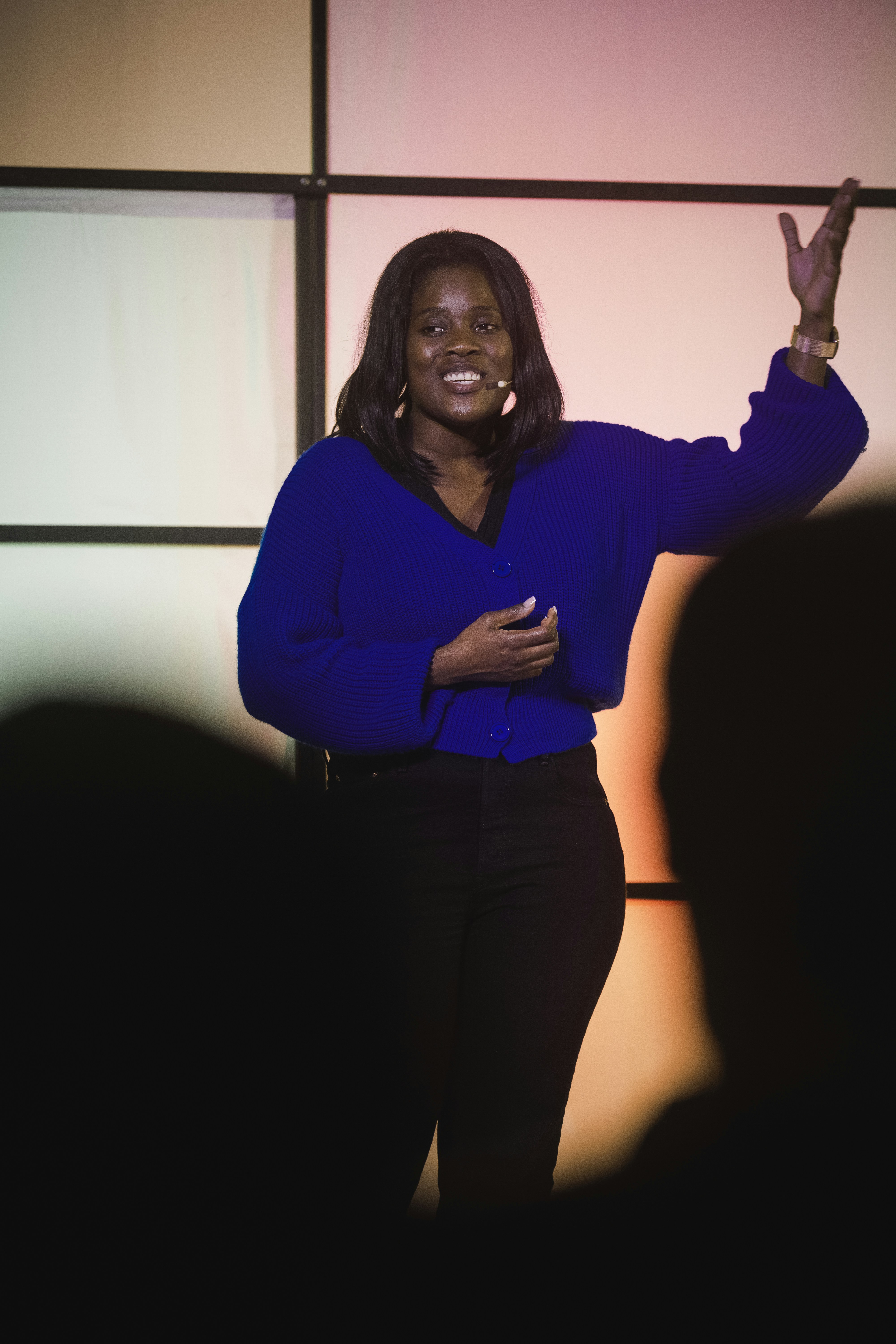 A woman in a blue shirt speaking on stage.