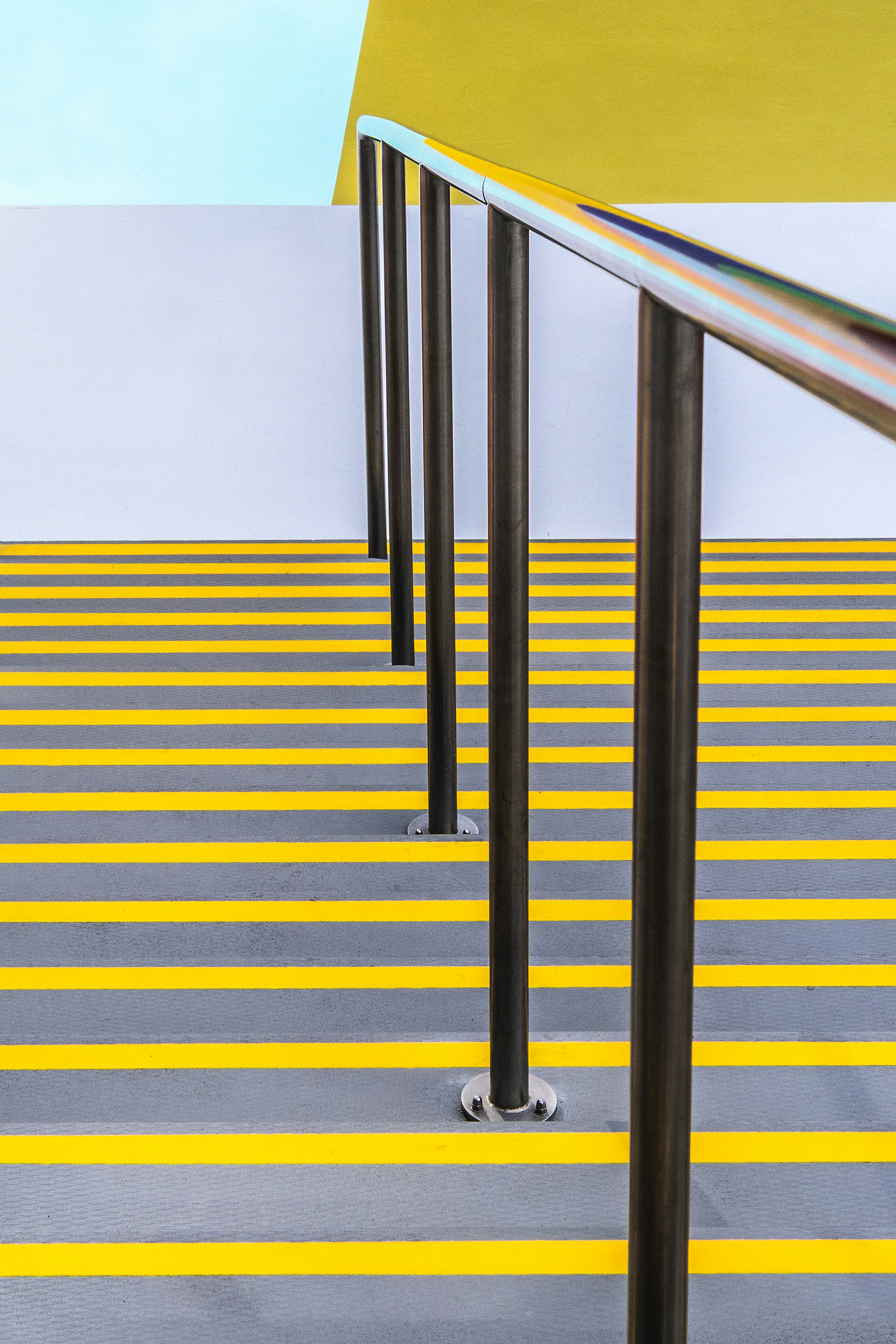 Modern staircase with yellow safety stripes and railing