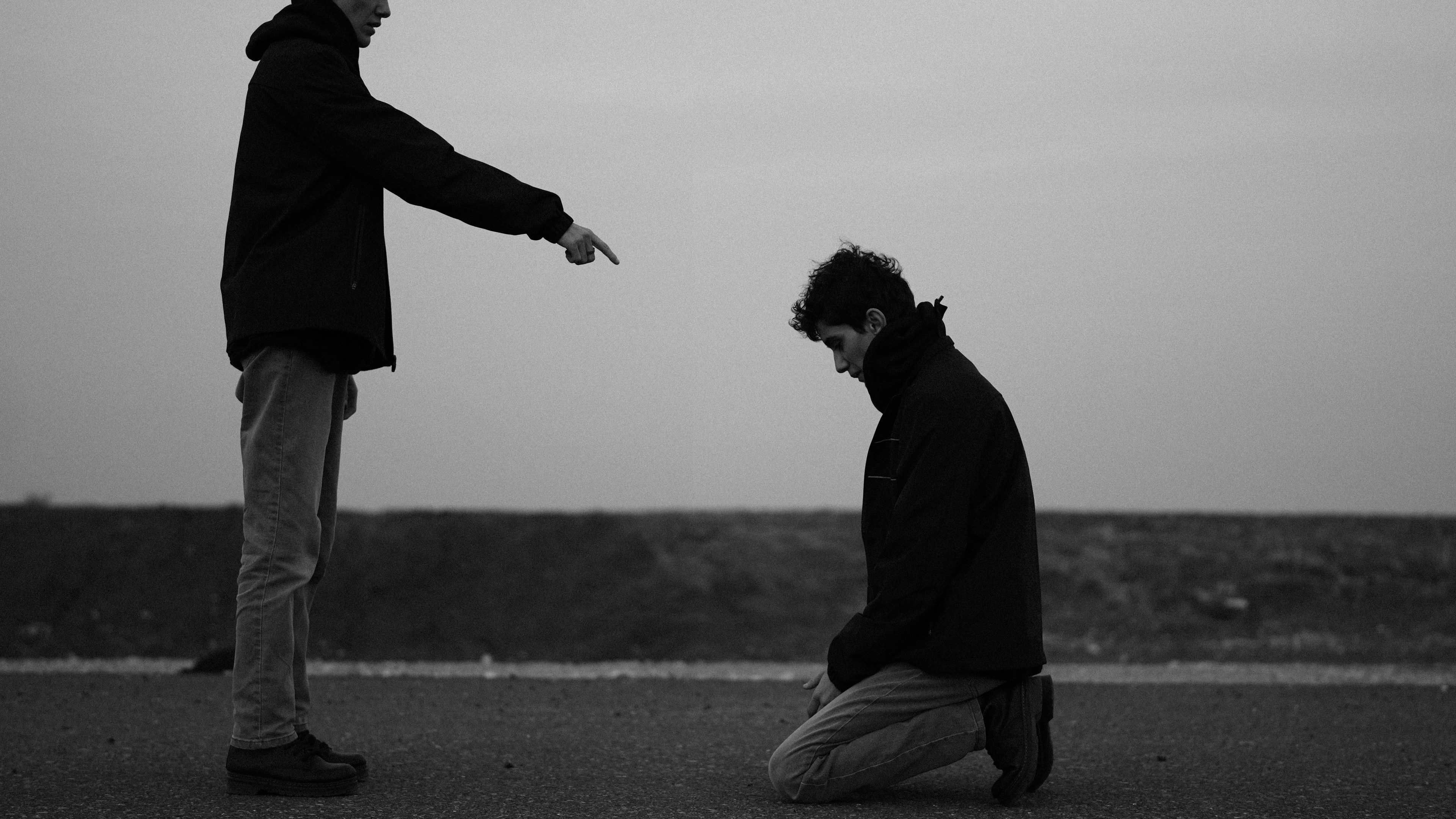 One person points at another kneeling person