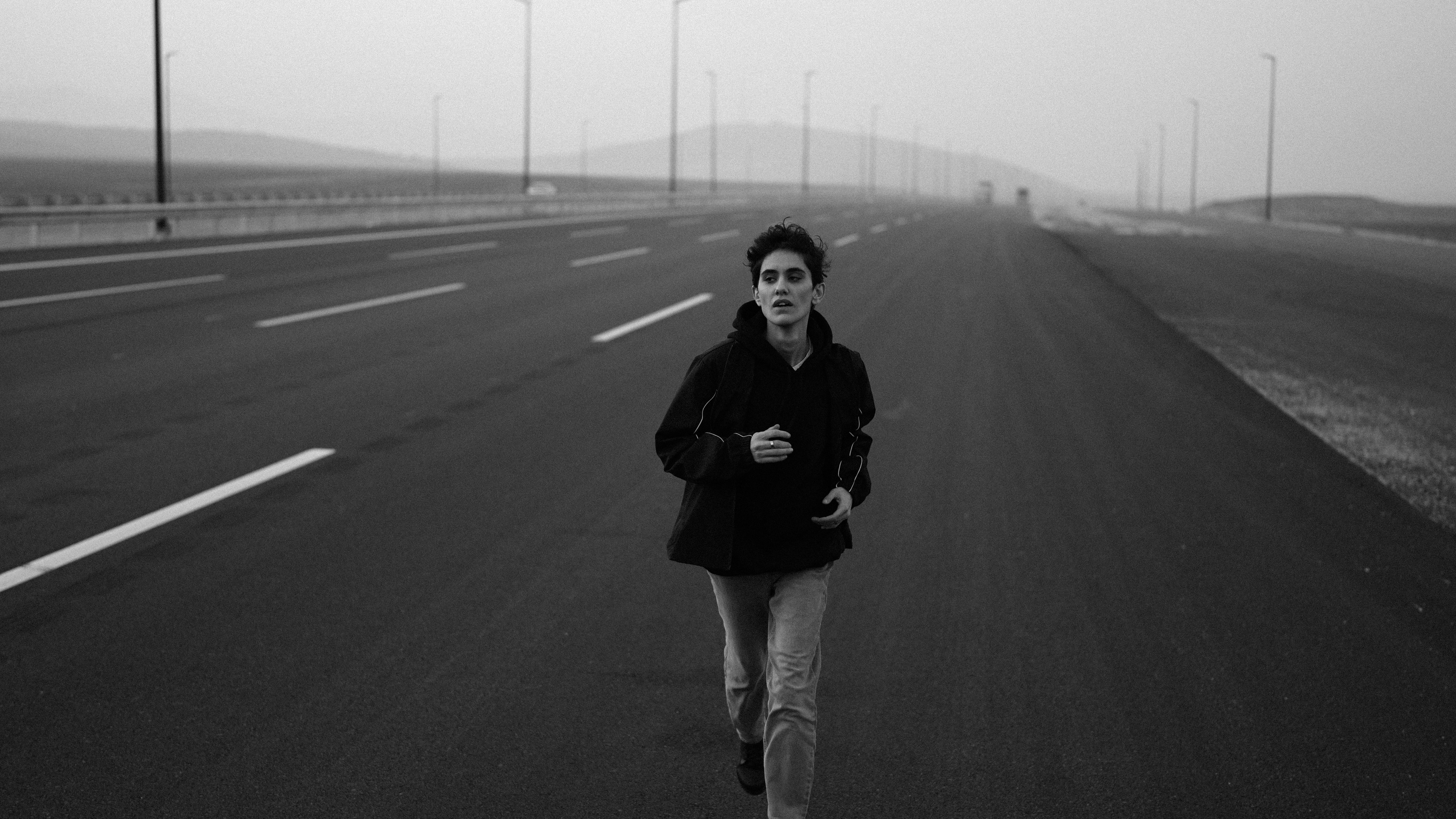 Young man running on a deserted road