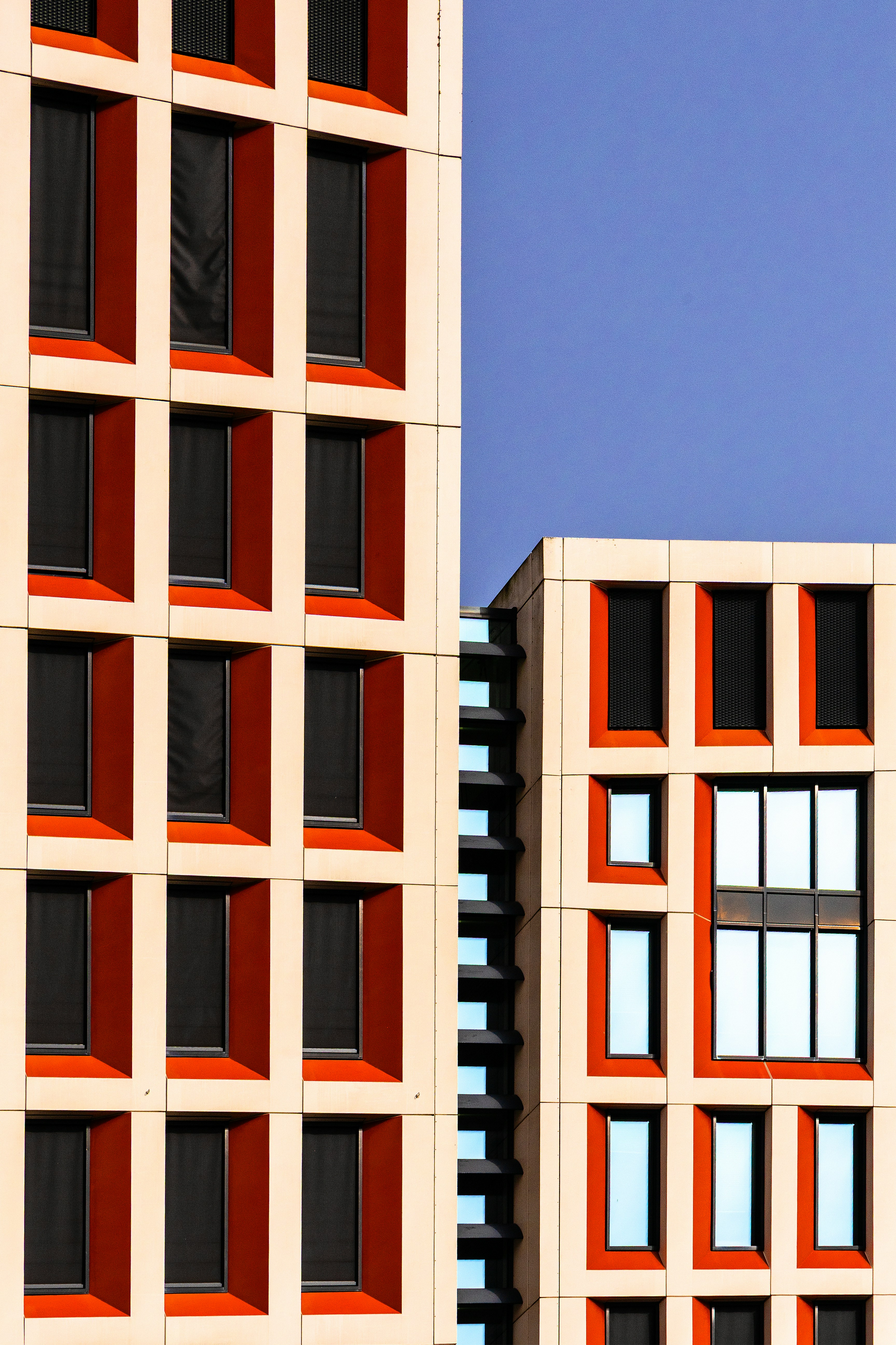 Modern buildings with geometric windows against blue sky