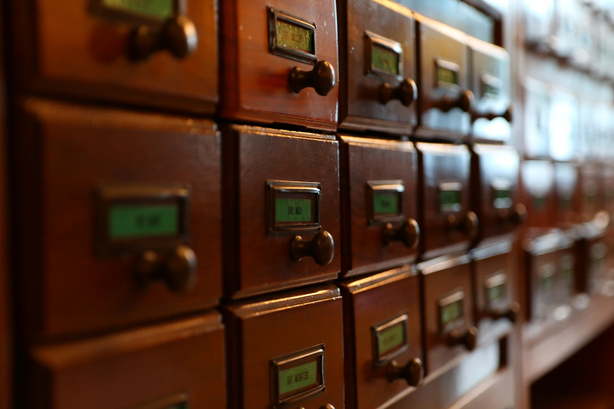 Rows of wooden card catalog drawers with small labels and brass pulls