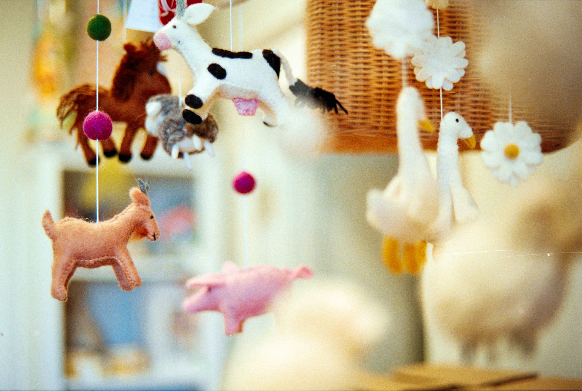 Felt farm animal toys hanging from a mobile.