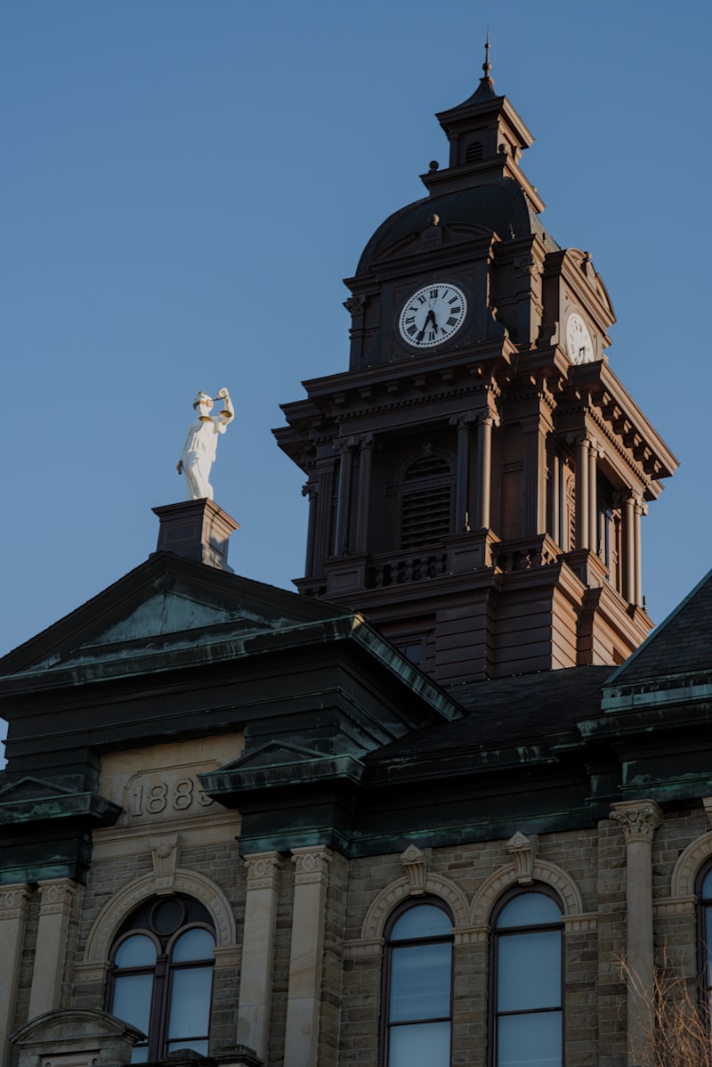 Historic courthouse with clock tower and justice statue