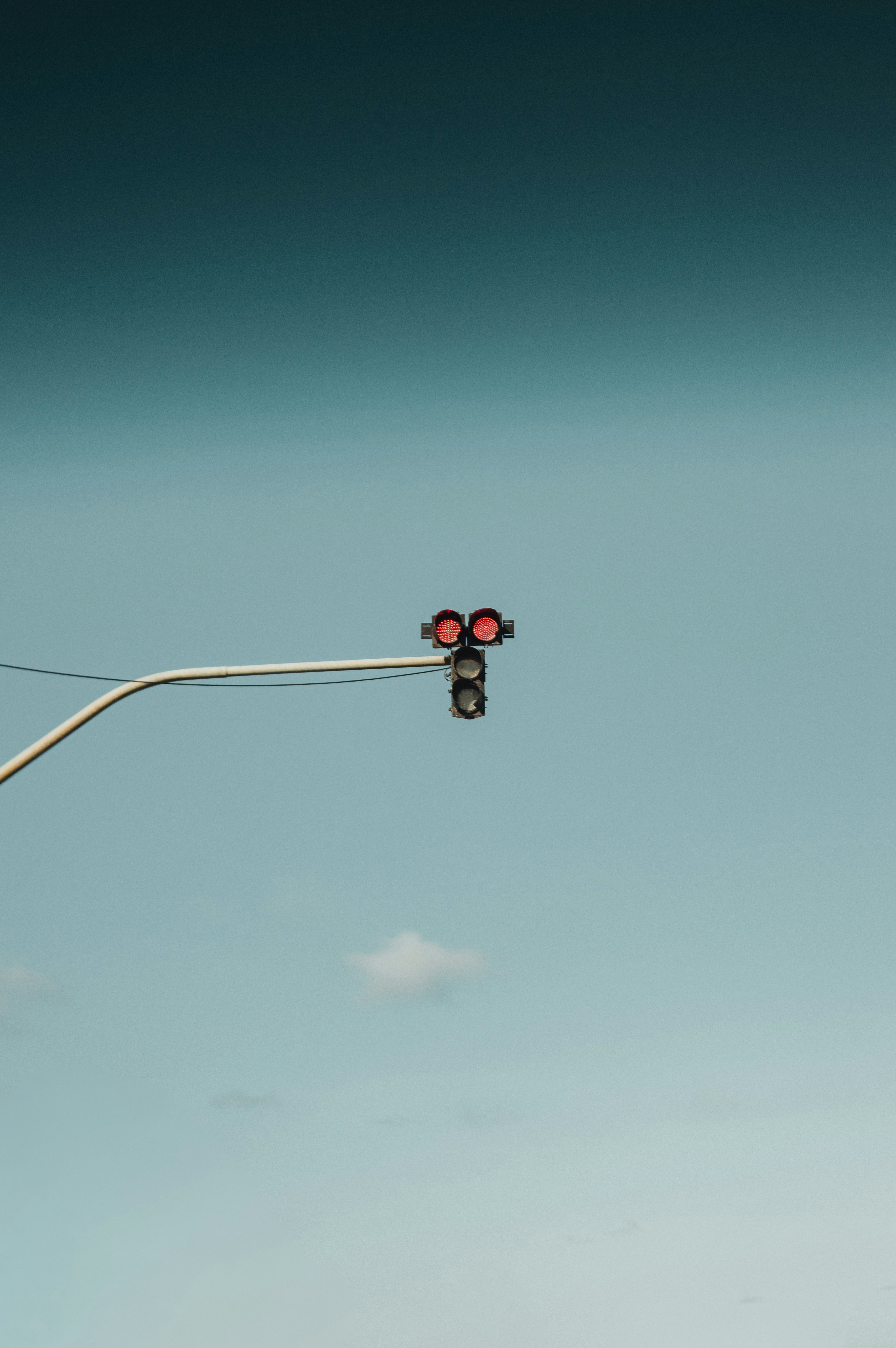 Red traffic light against a clear blue sky