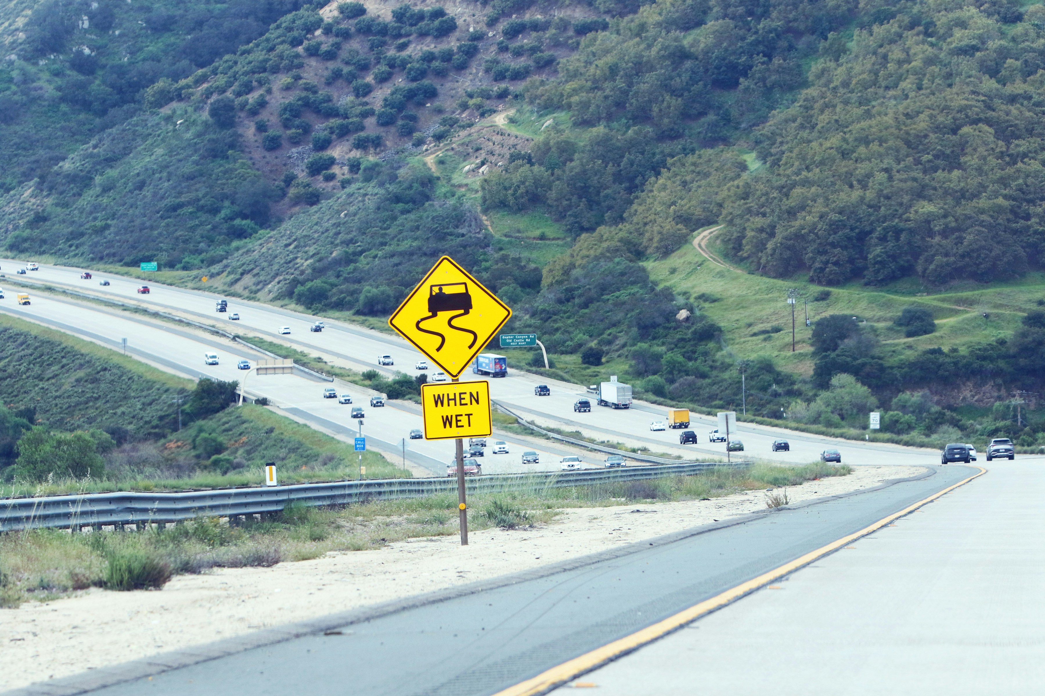 Slippery when wet road sign on highway