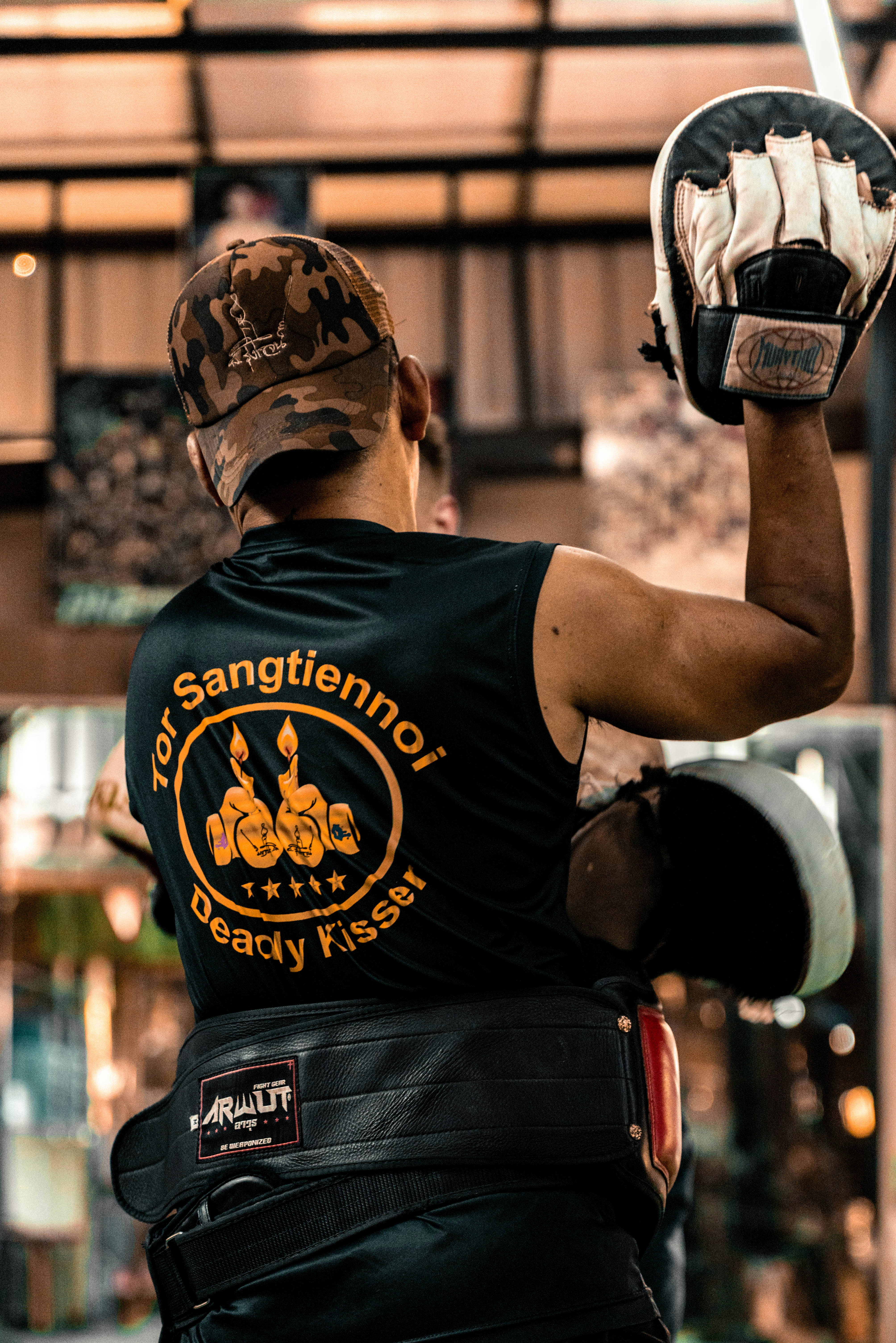 Boxertraining mit Fokushandschuhen im Fitnessstudio.