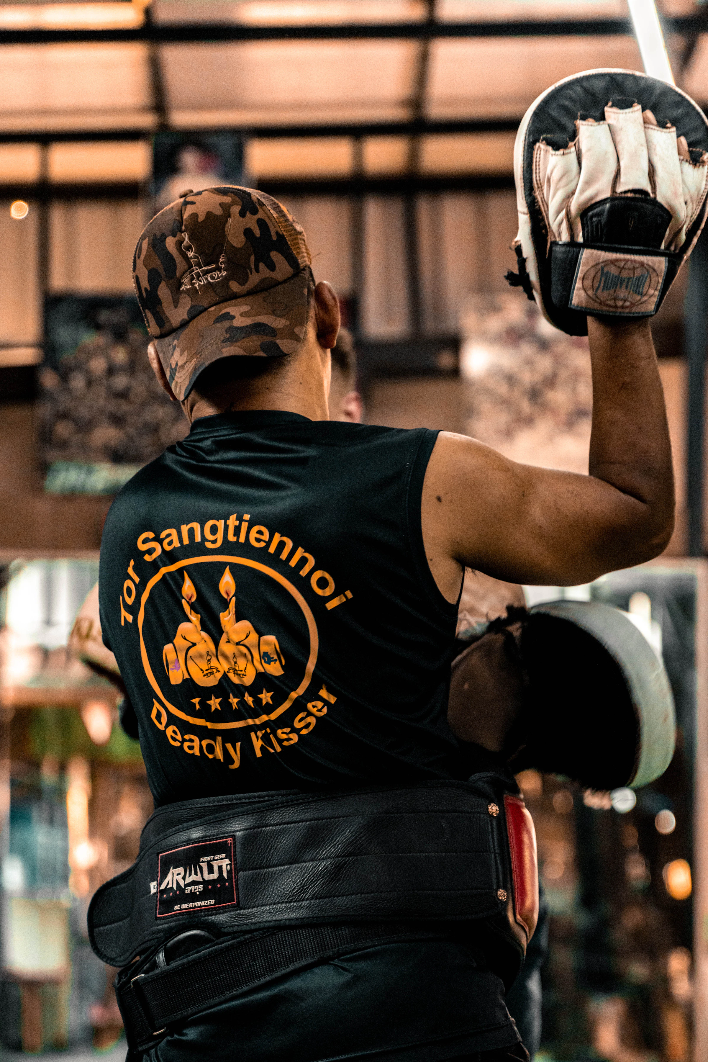 A boxer practicing with a coach and focus mitts