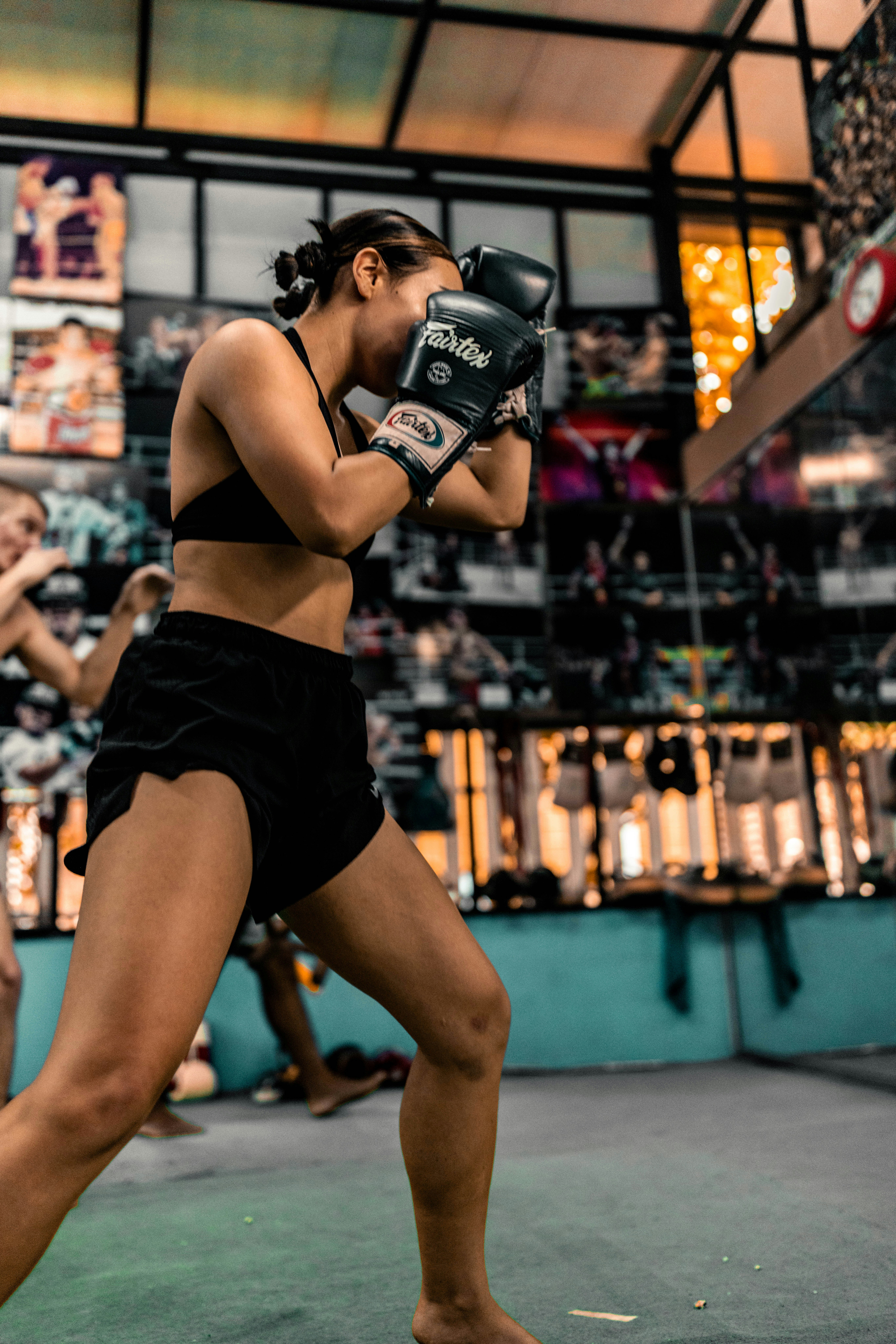 Mulher treinando muay thai em uma academia.