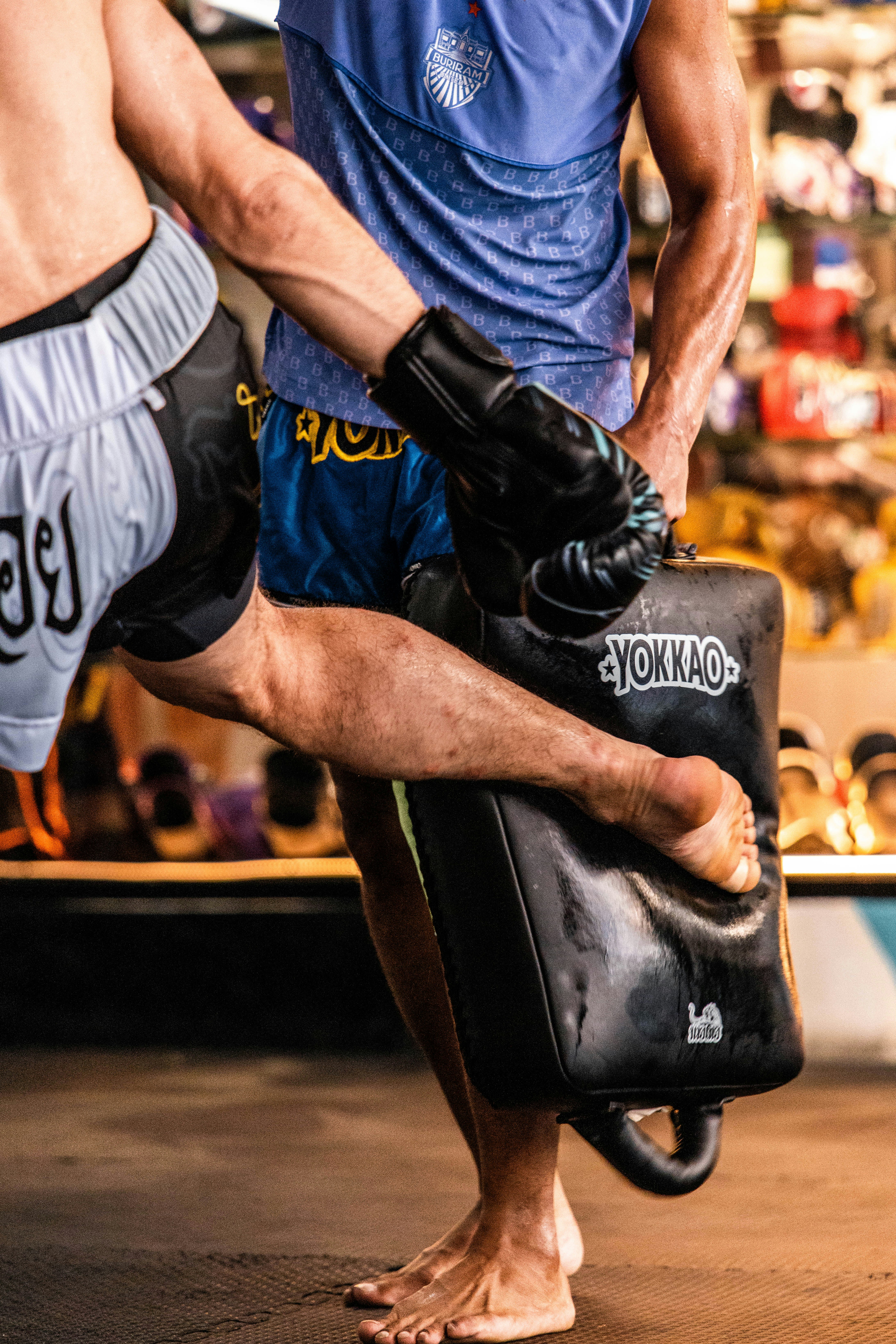 Der Kämpfer tritt beim Trainingspad während des Muay-Thai-Trainings.