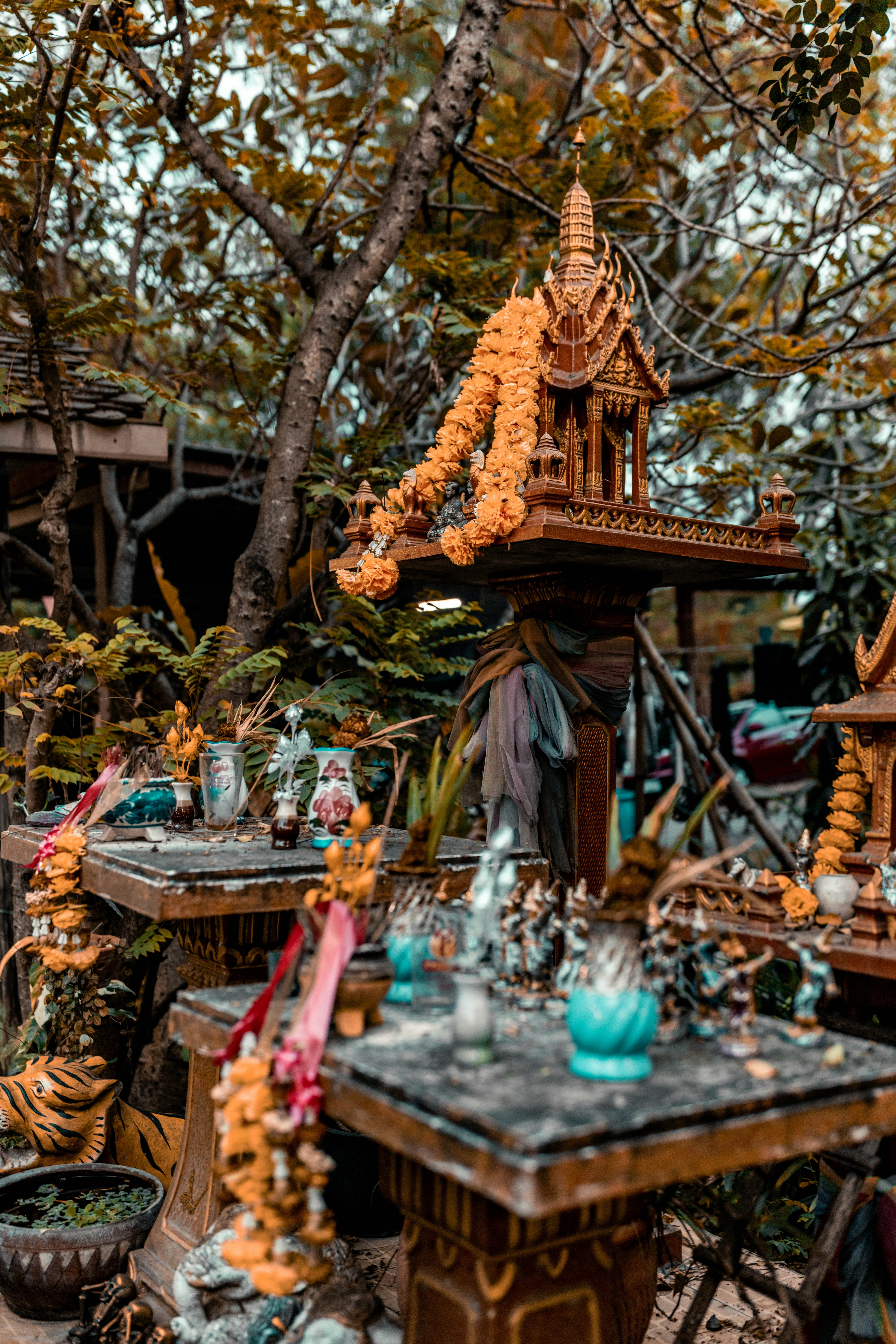 Kleine Schreine, die draußen mit Blumen und Opfergaben geschmückt sind.