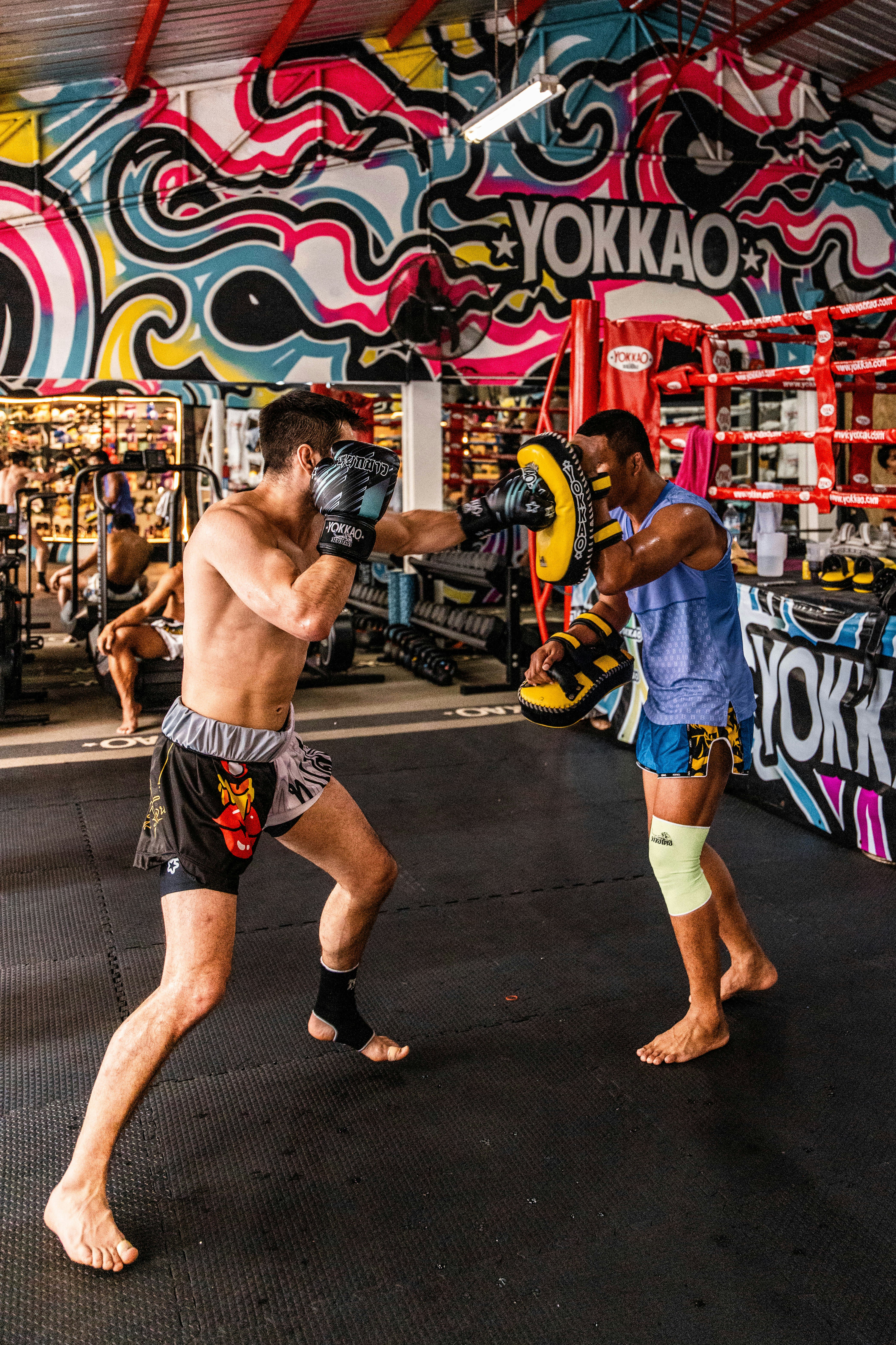 Zwei Männer trainieren Muay Thai in einem Fitnessstudio.