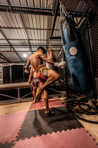 Man training muay thai with a punching bag.