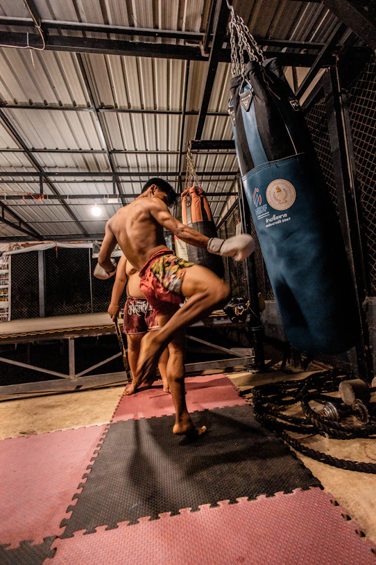Man training muay thai with a punching bag.