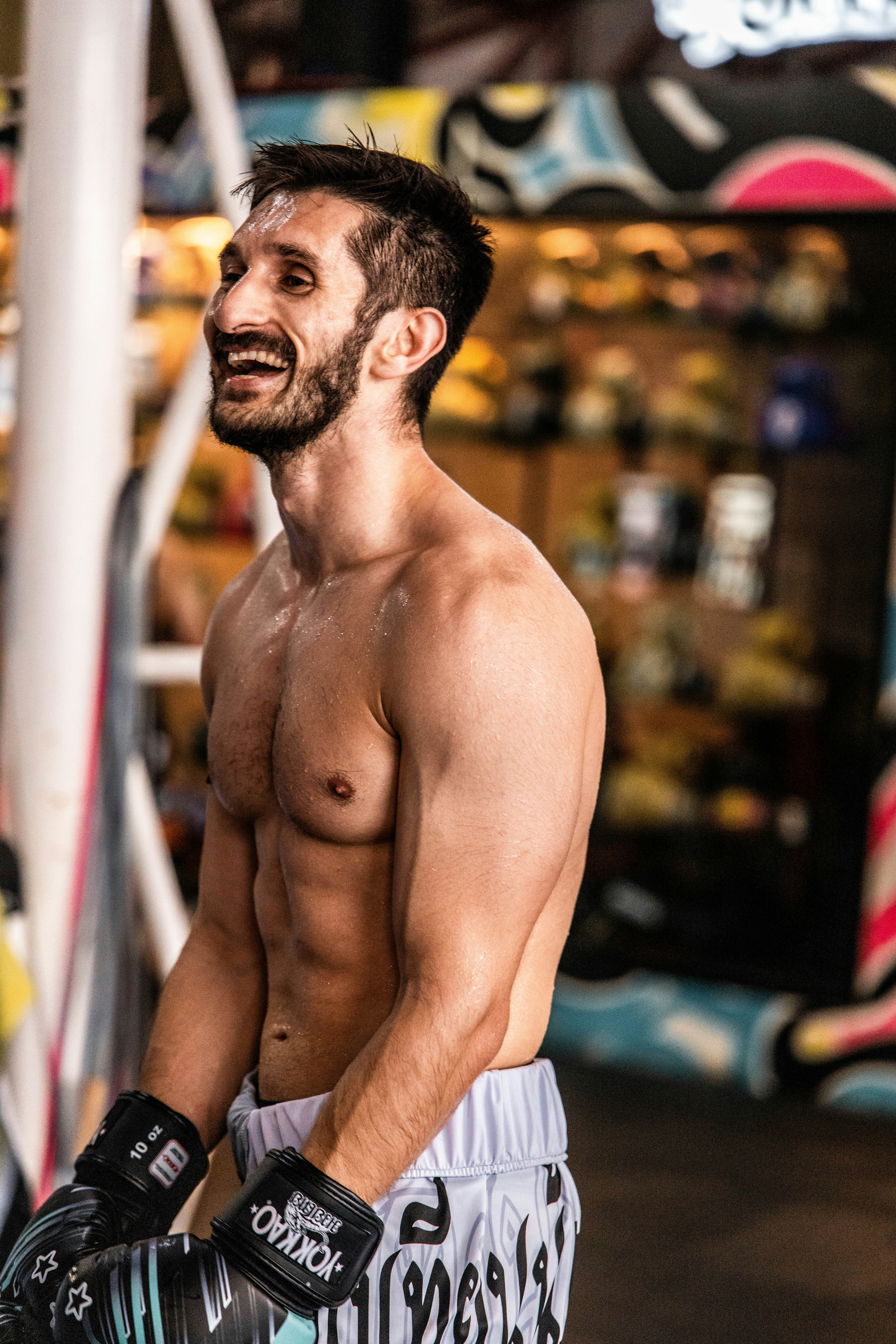 A man with boxing gloves smiles during training