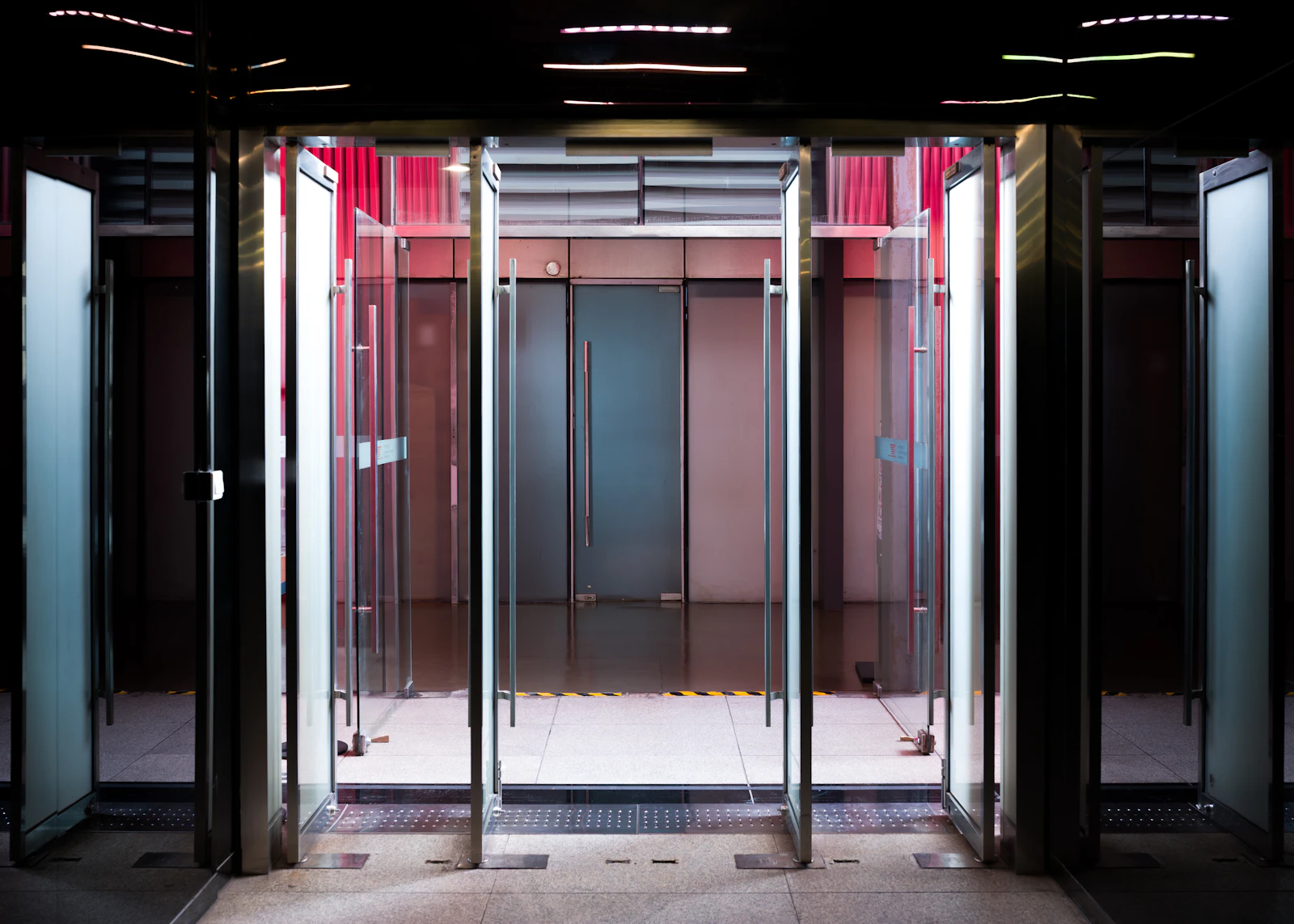A row of open glass doors at the entrance to a modern building