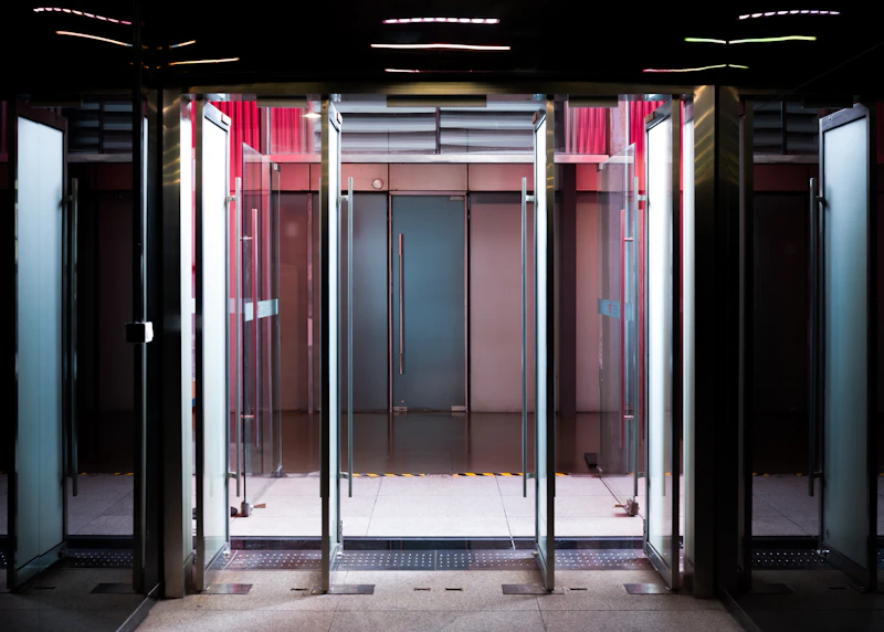 A row of open glass doors at the entrance to a modern building