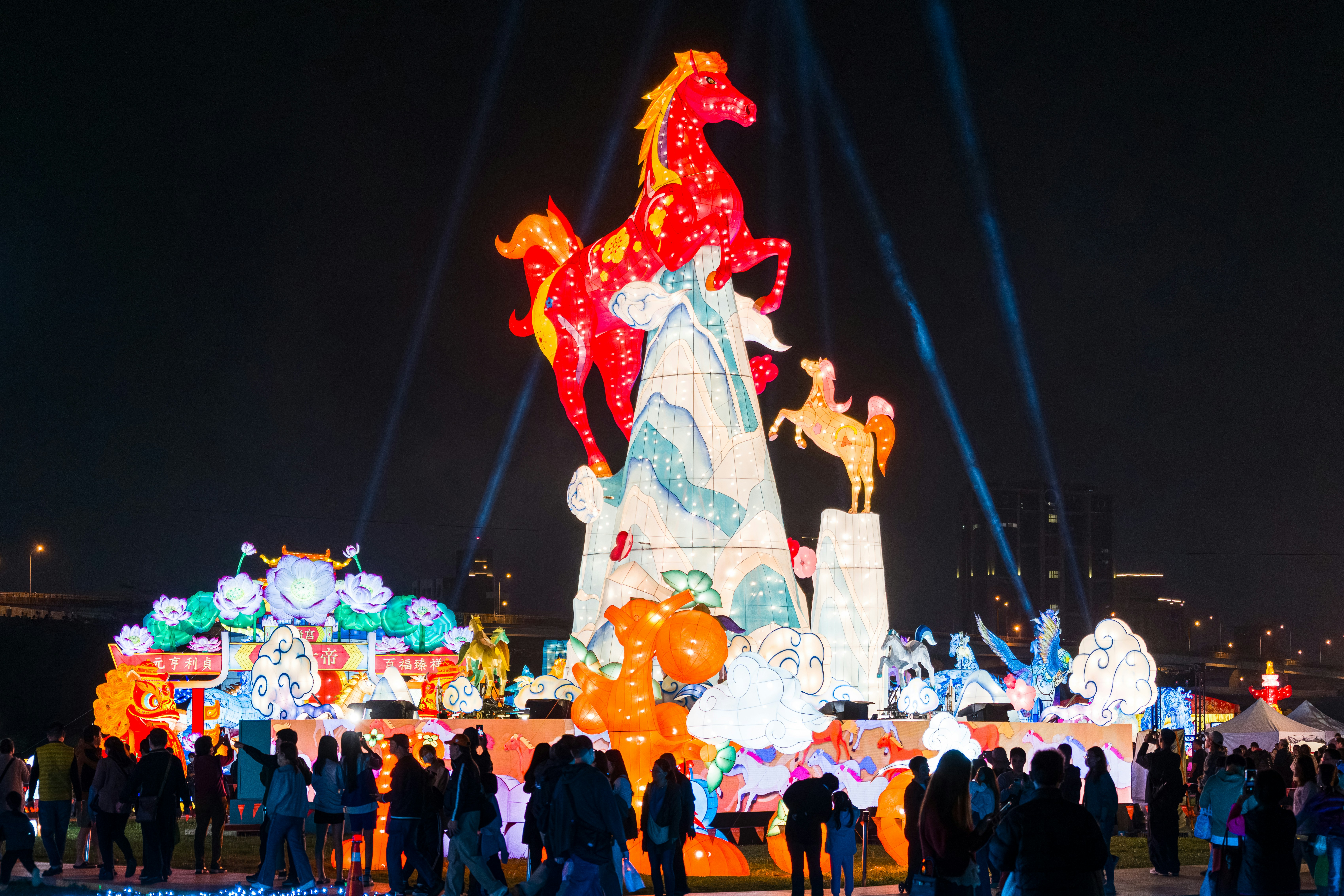Giant illuminated horse sculptures at a nighttime festival