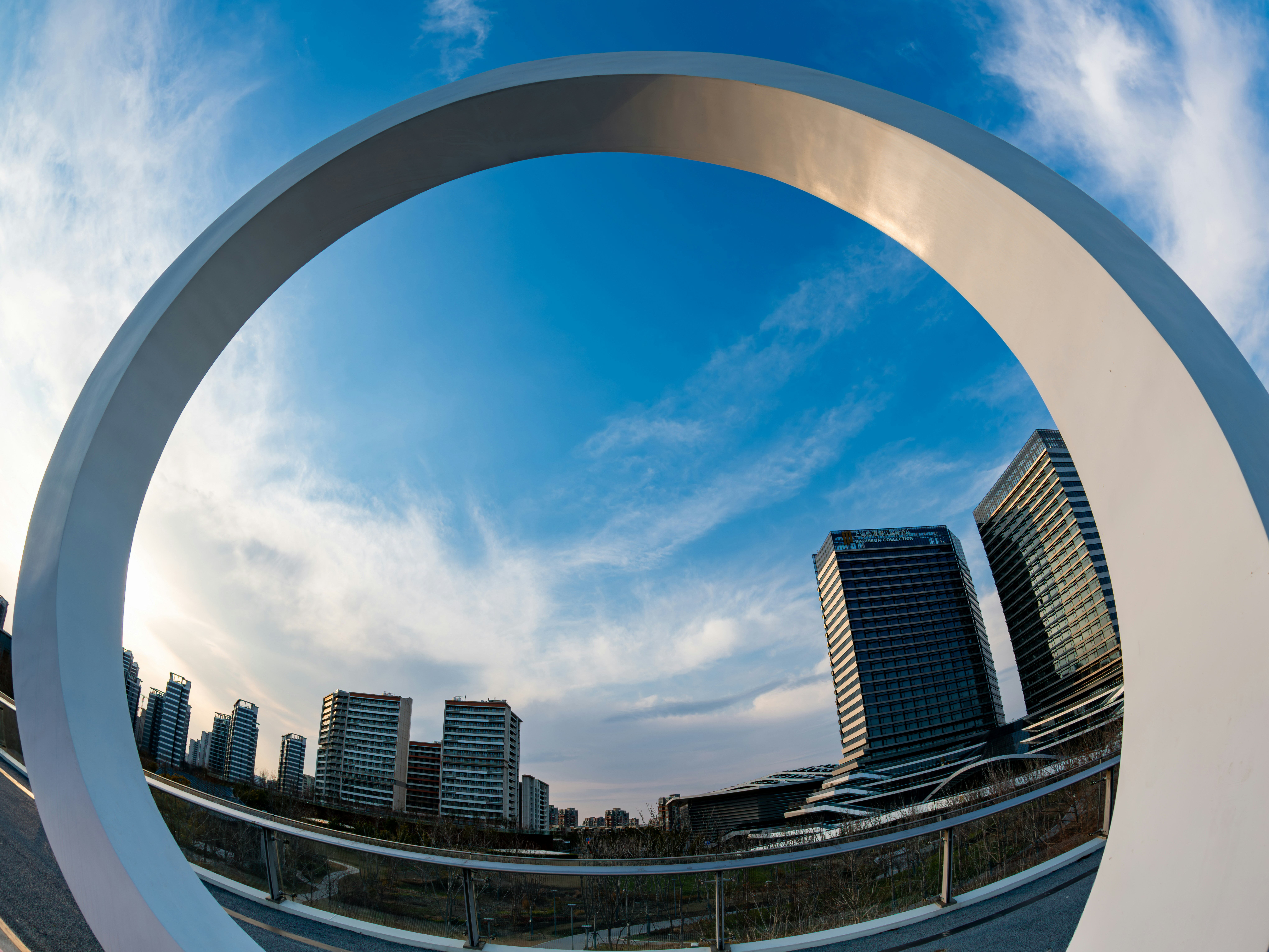 Modern buildings seen through a large white archway