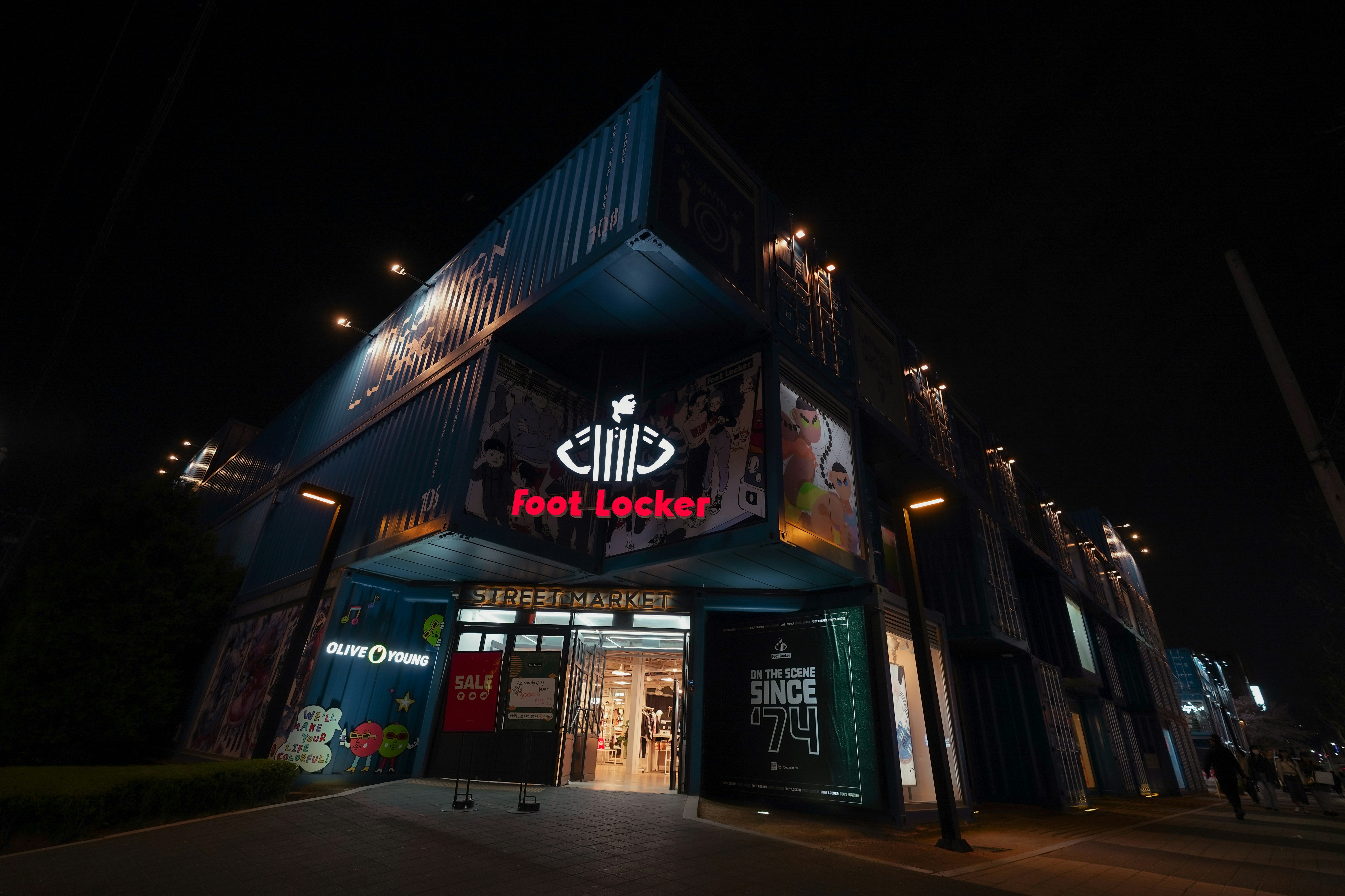 Foot locker store illuminated at night with signage visible