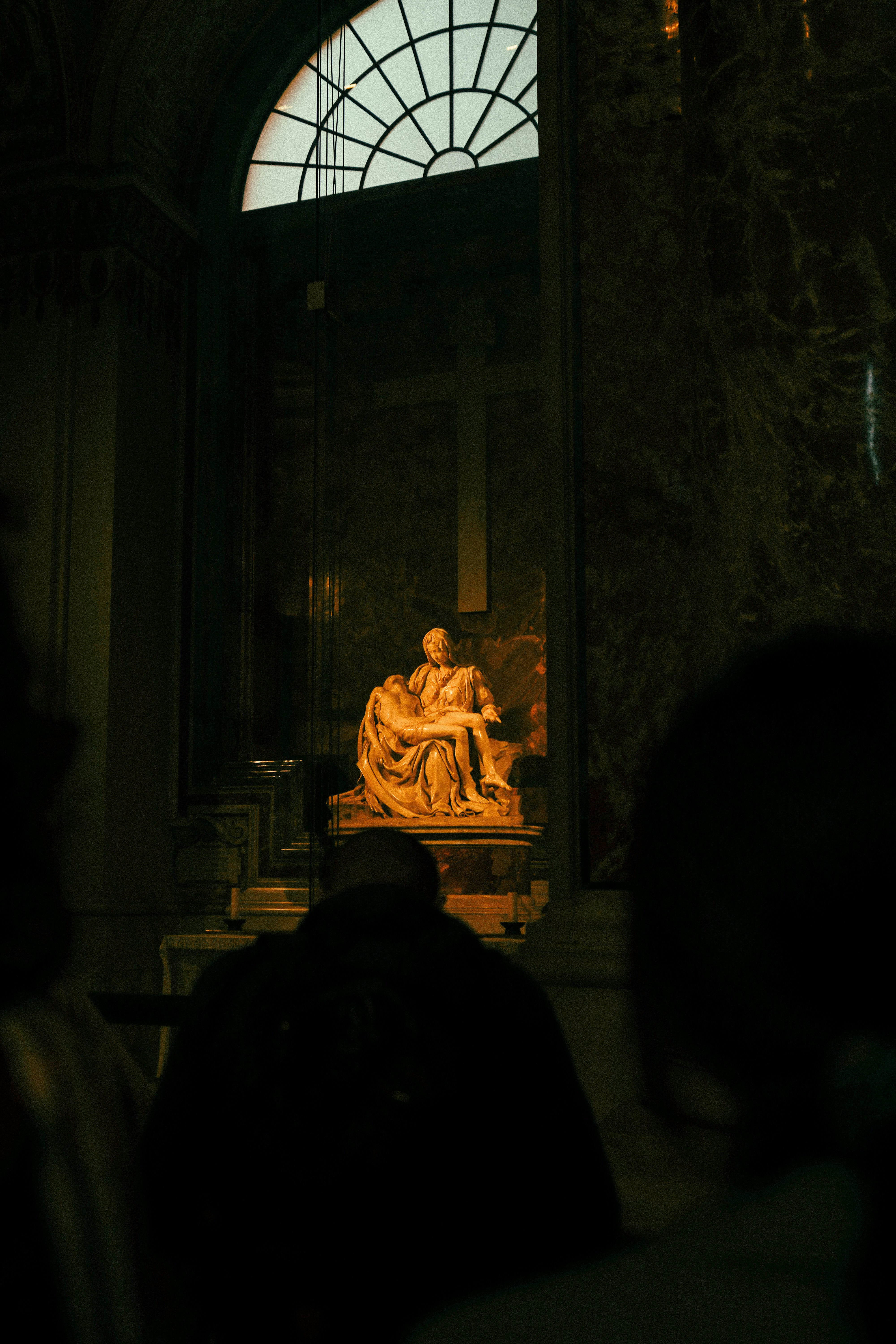 Statue of mary holding jesus in a dark church.