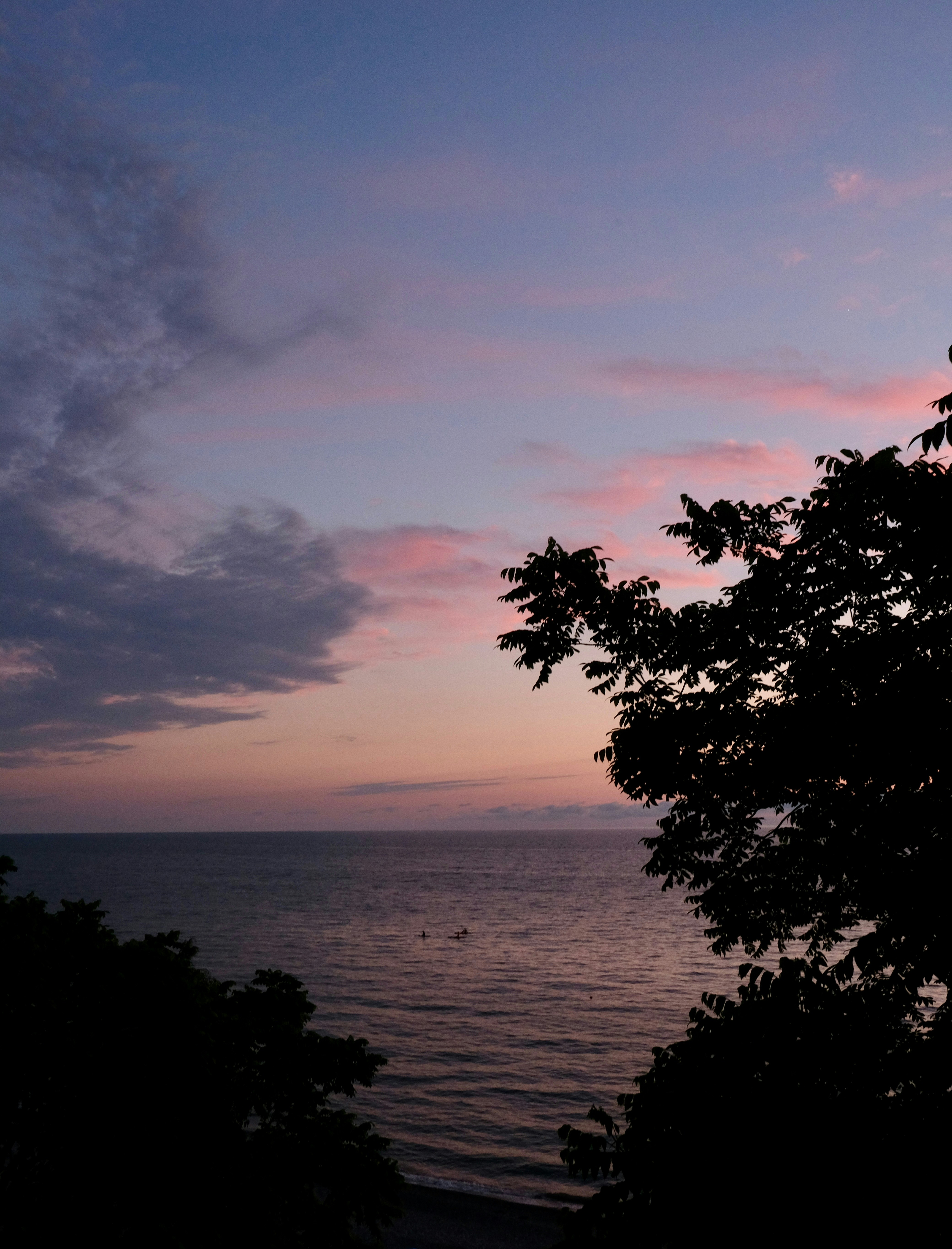 Pink and purple clouds over the ocean at dusk.