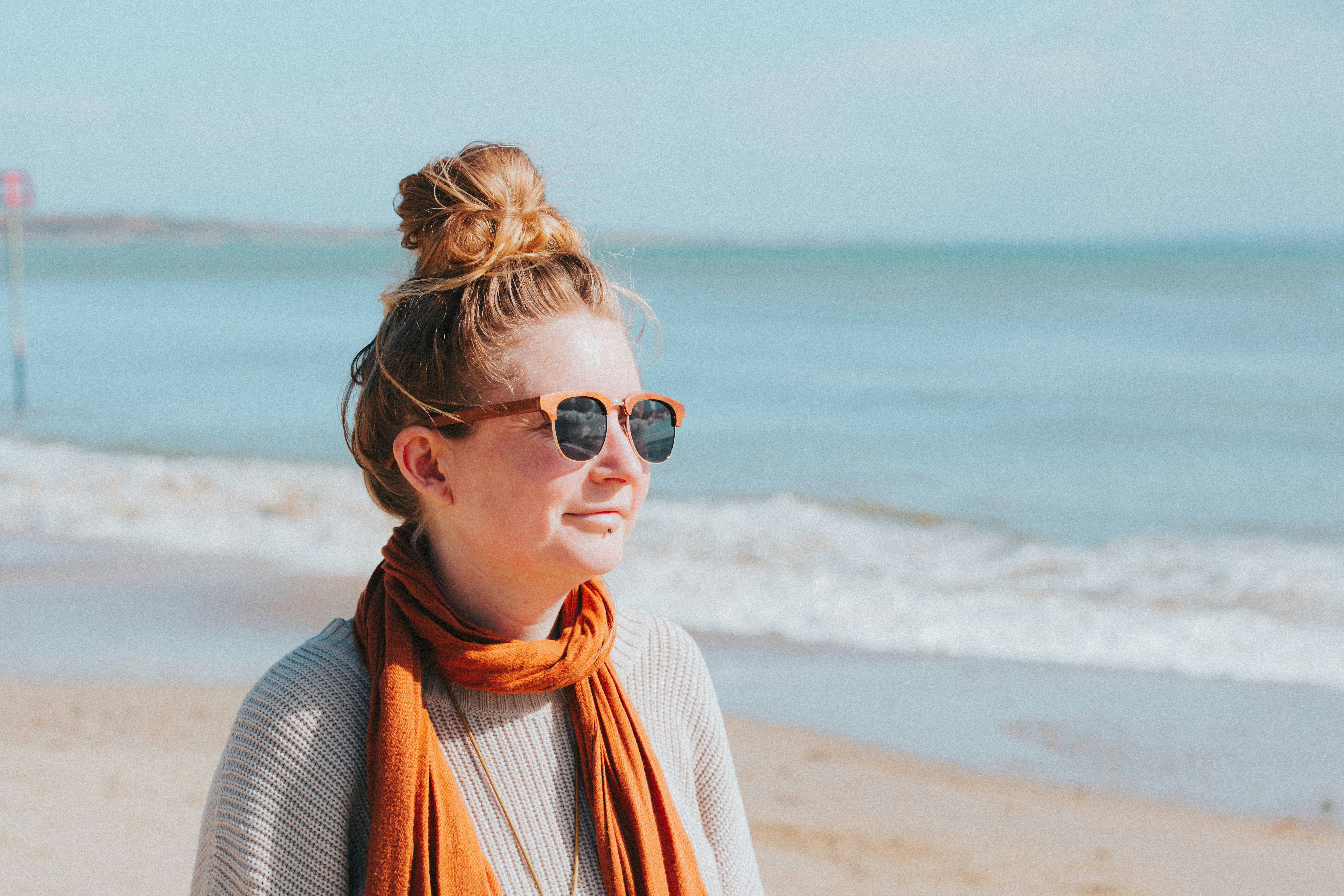 A young woman wearing sunglasses on a sunny beach