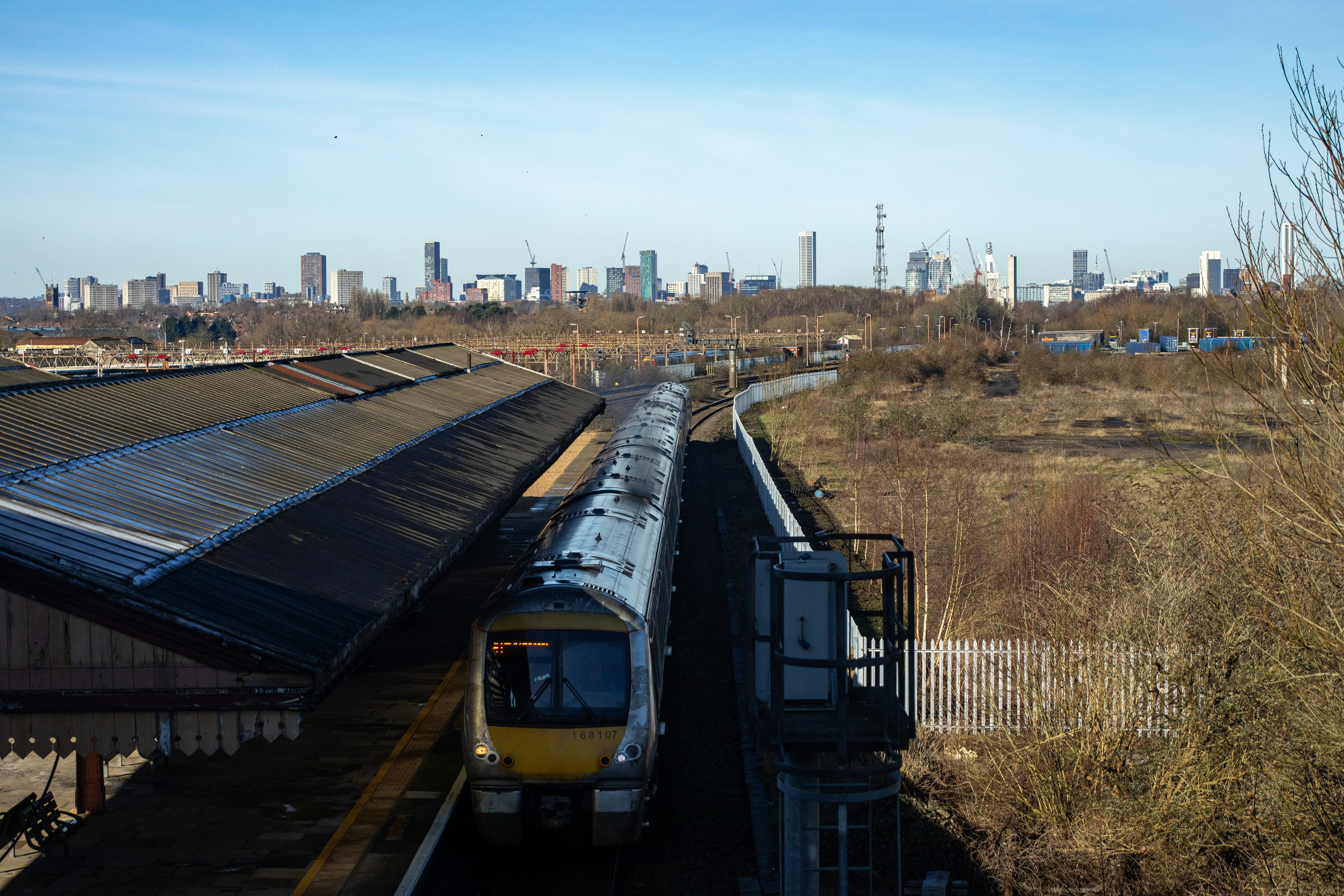 Train at a station with city skyline background