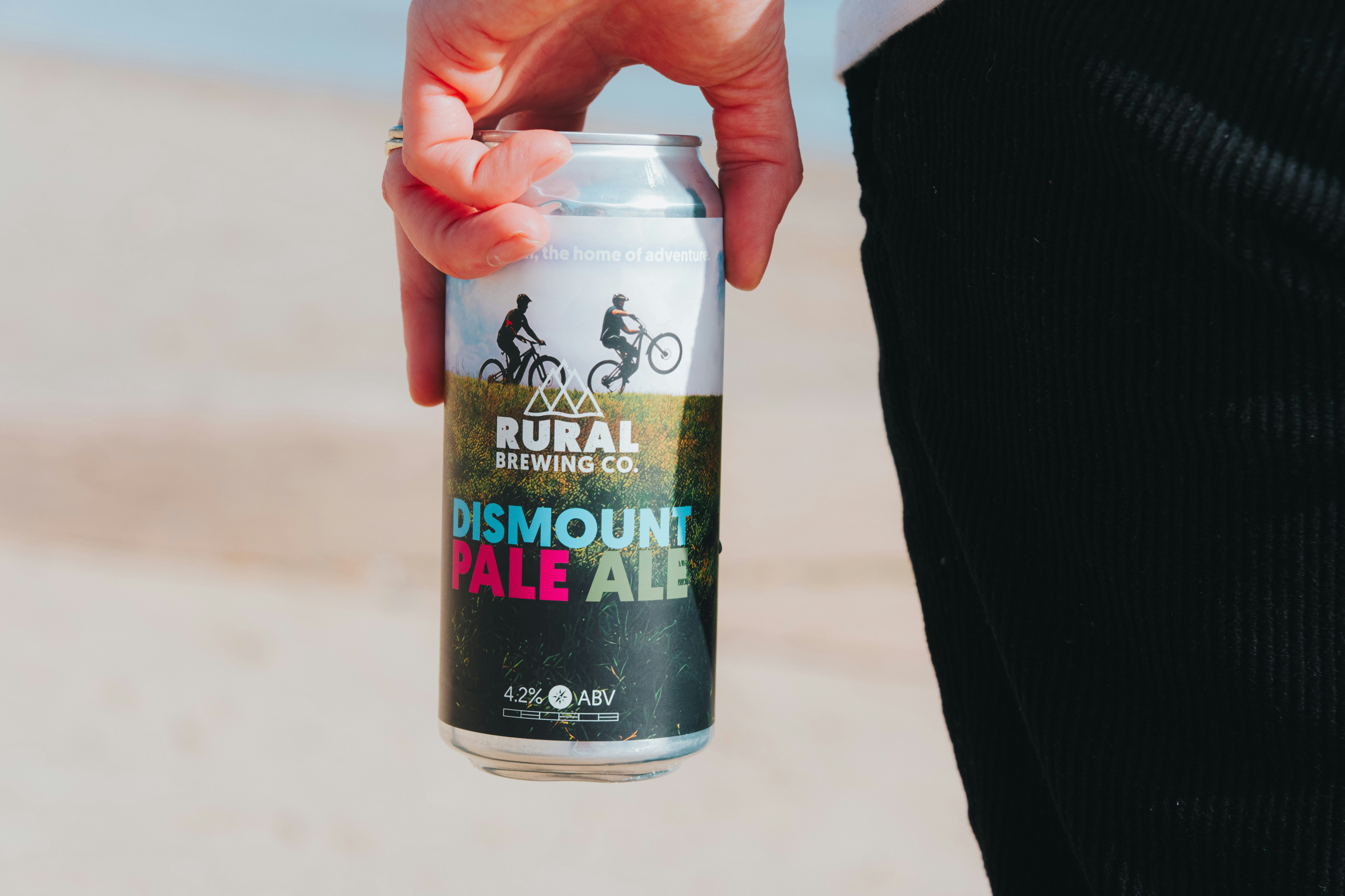 Hand holding a can of dismount pale ale