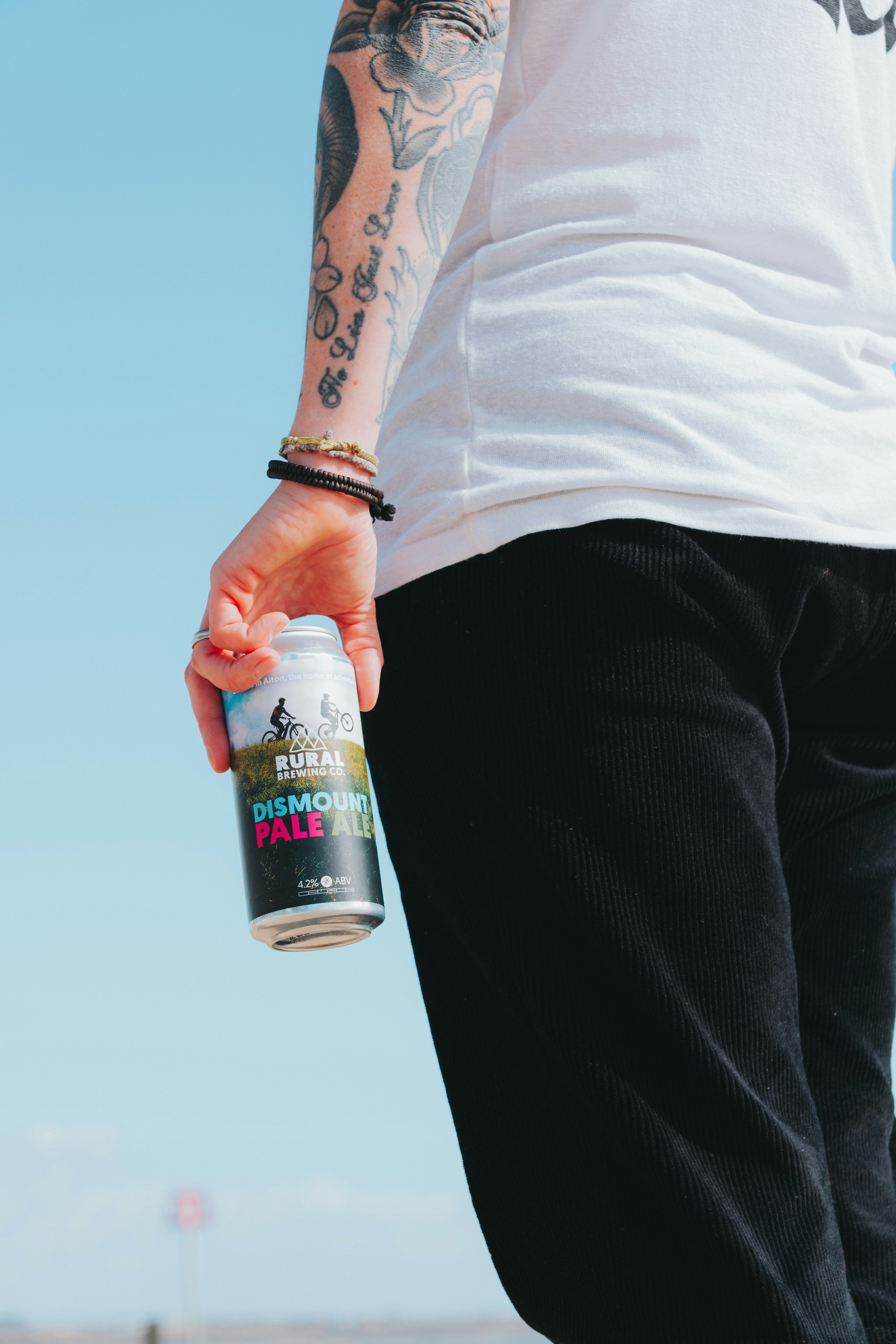 Person holding a can of ale with tattoos.