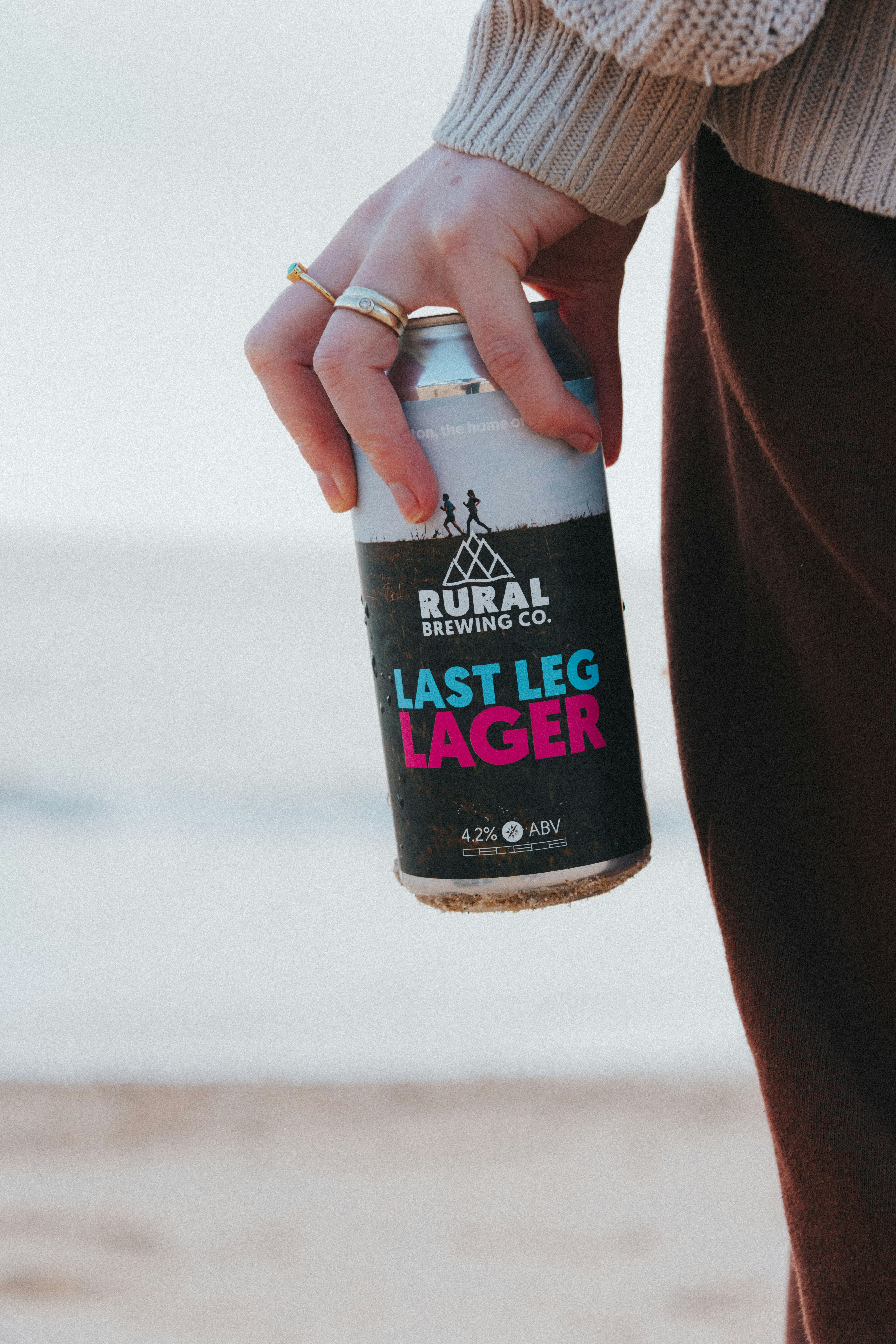 Hand holding a can of last leg lager beer