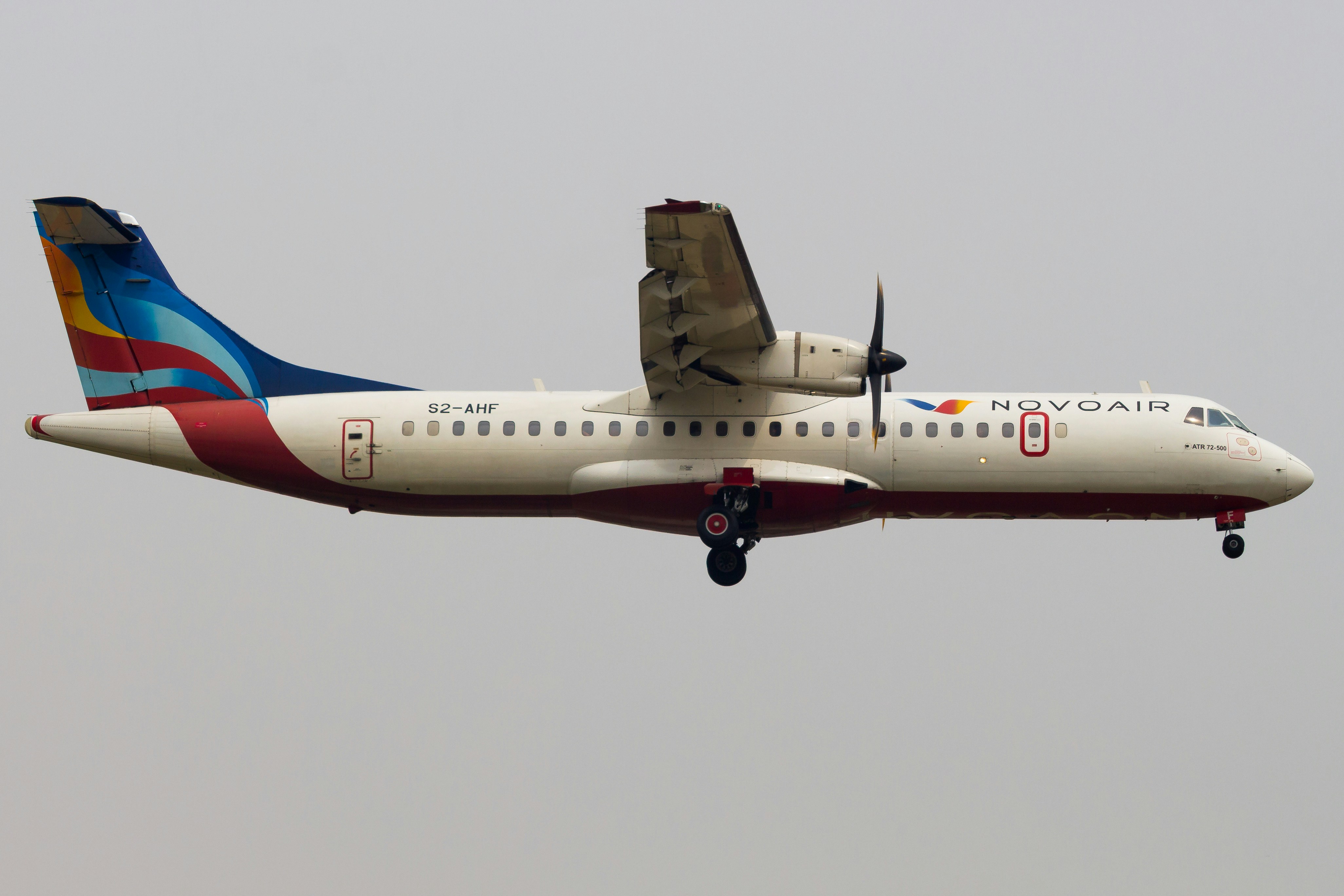 A turboprop airplane in flight against a cloudy sky.