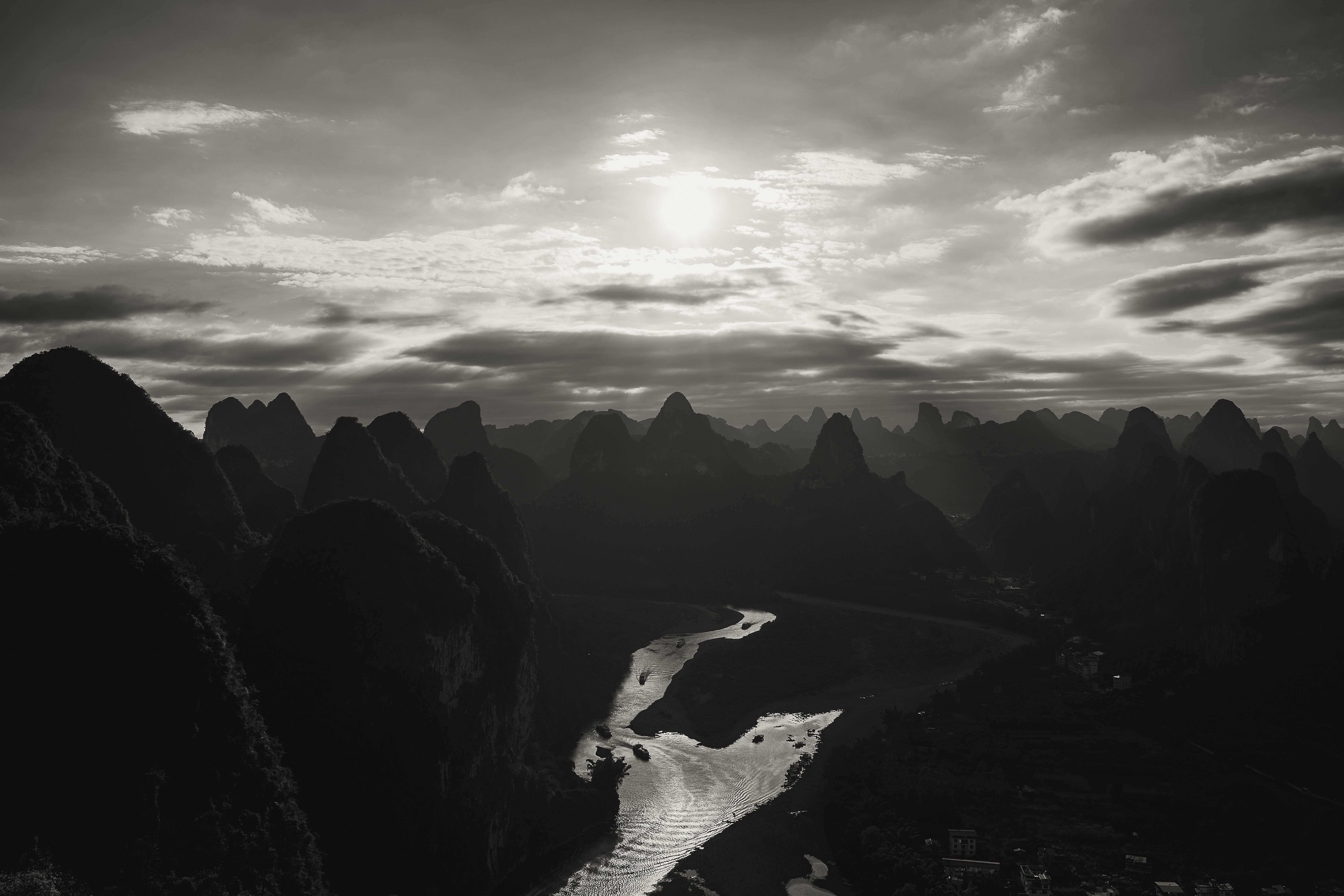 Dramatic karst mountains and river under cloudy sky