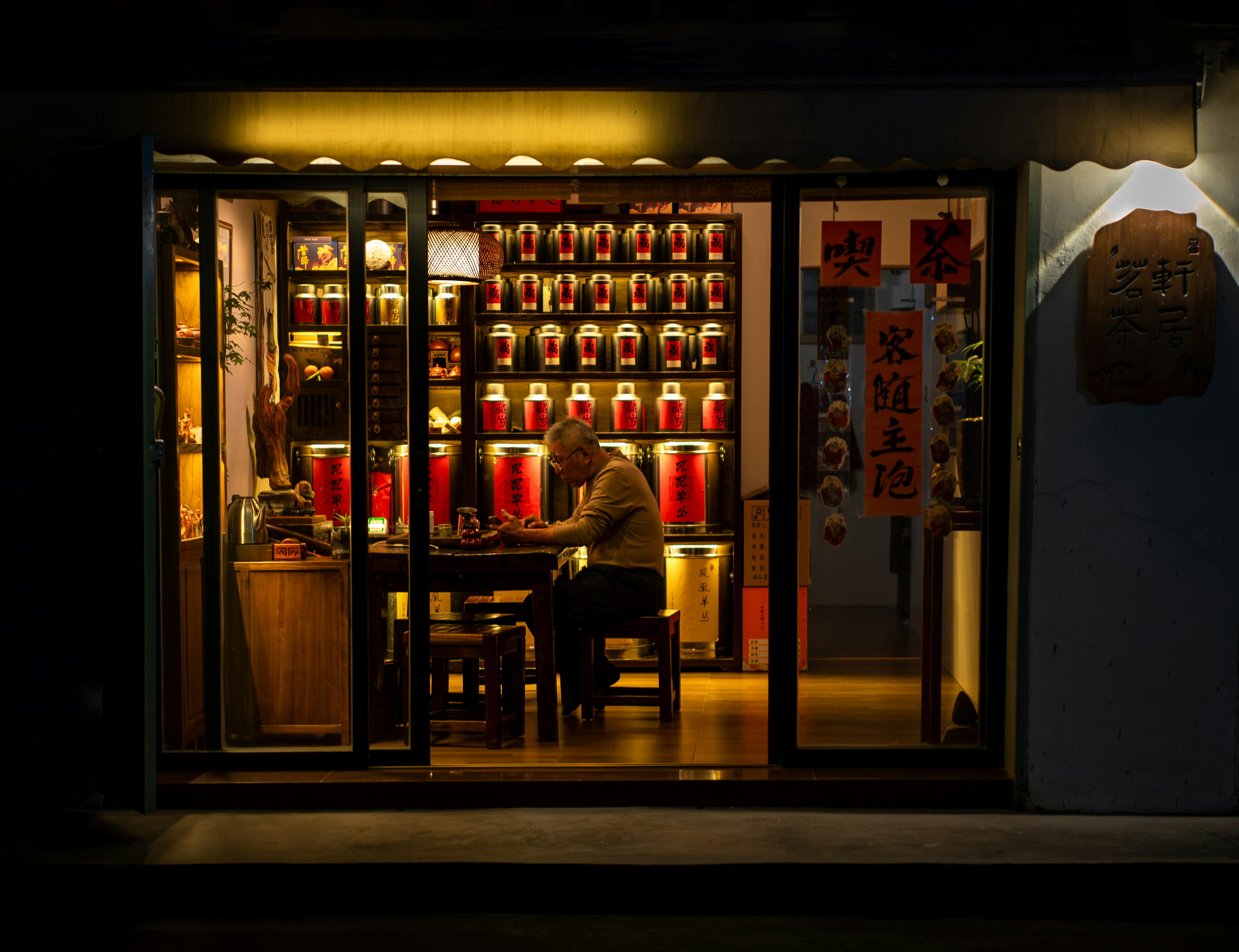 Warmly lit shop seen from the street at night