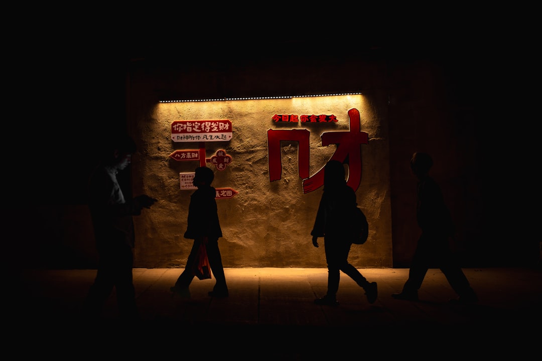 Chinese city street at night with pedestrians and illuminated buildings