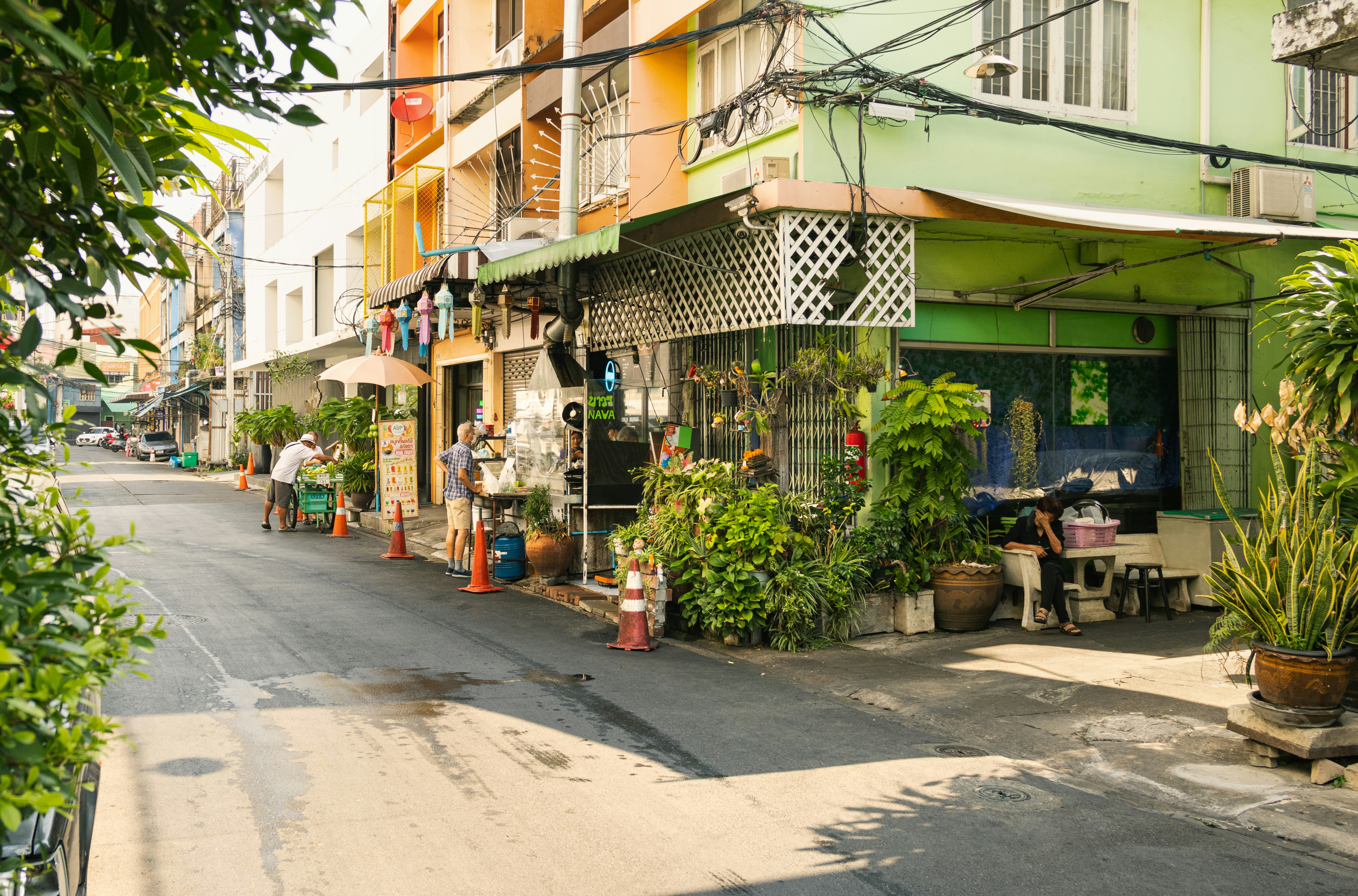 Una calle estrecha bordeada de edificios y plantas.