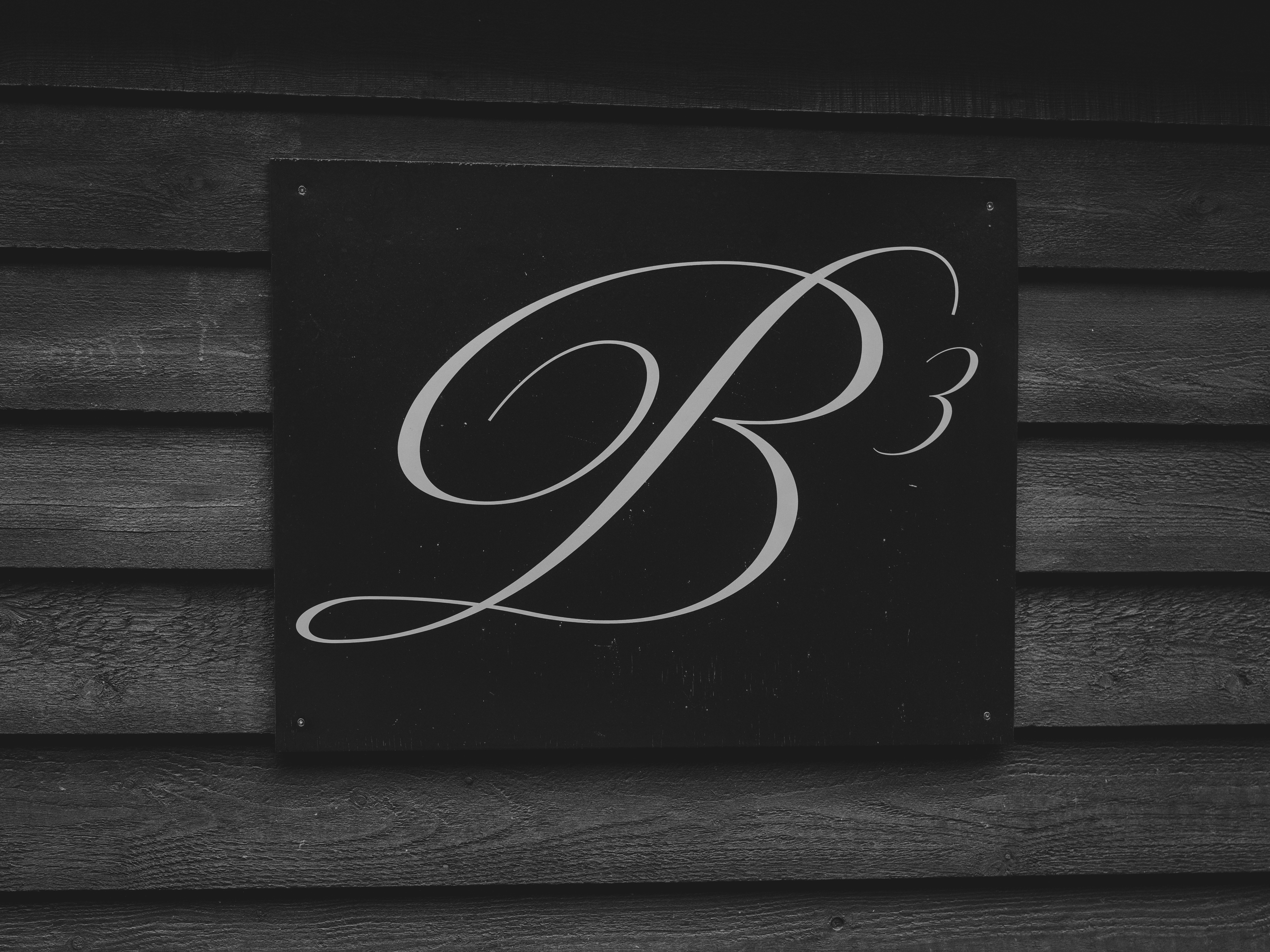 Um logo estilizado b3 em uma parede de madeira