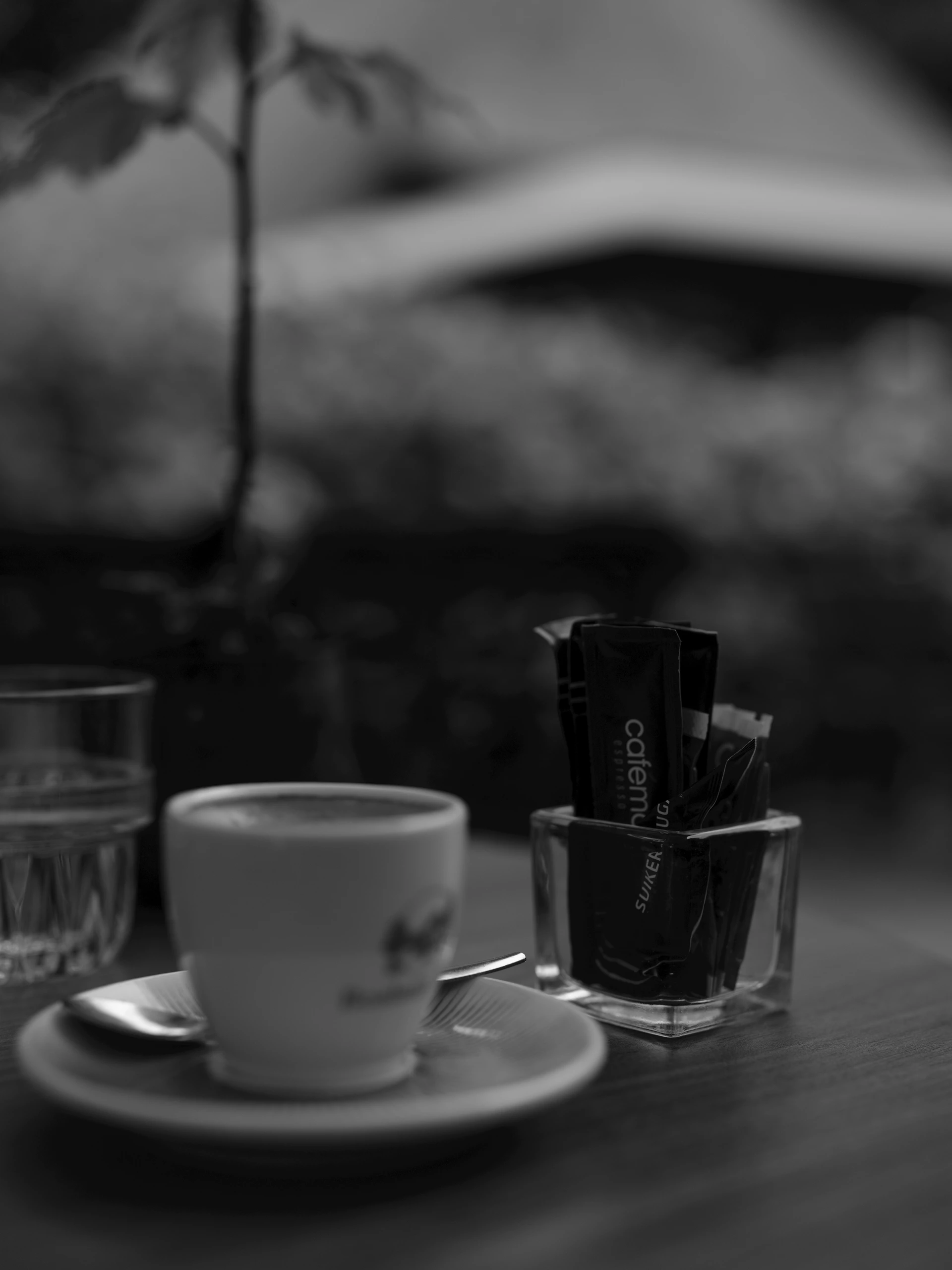 A cup of coffee with sugar packets on a table