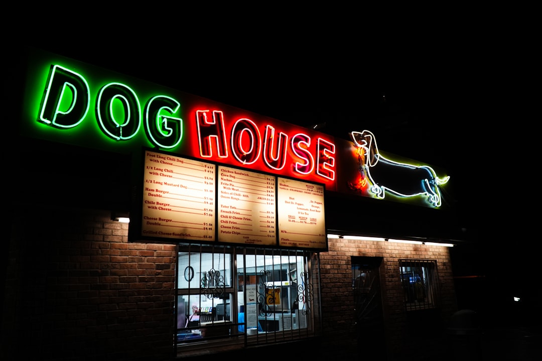 Neon sign for dog house restaurant at night.