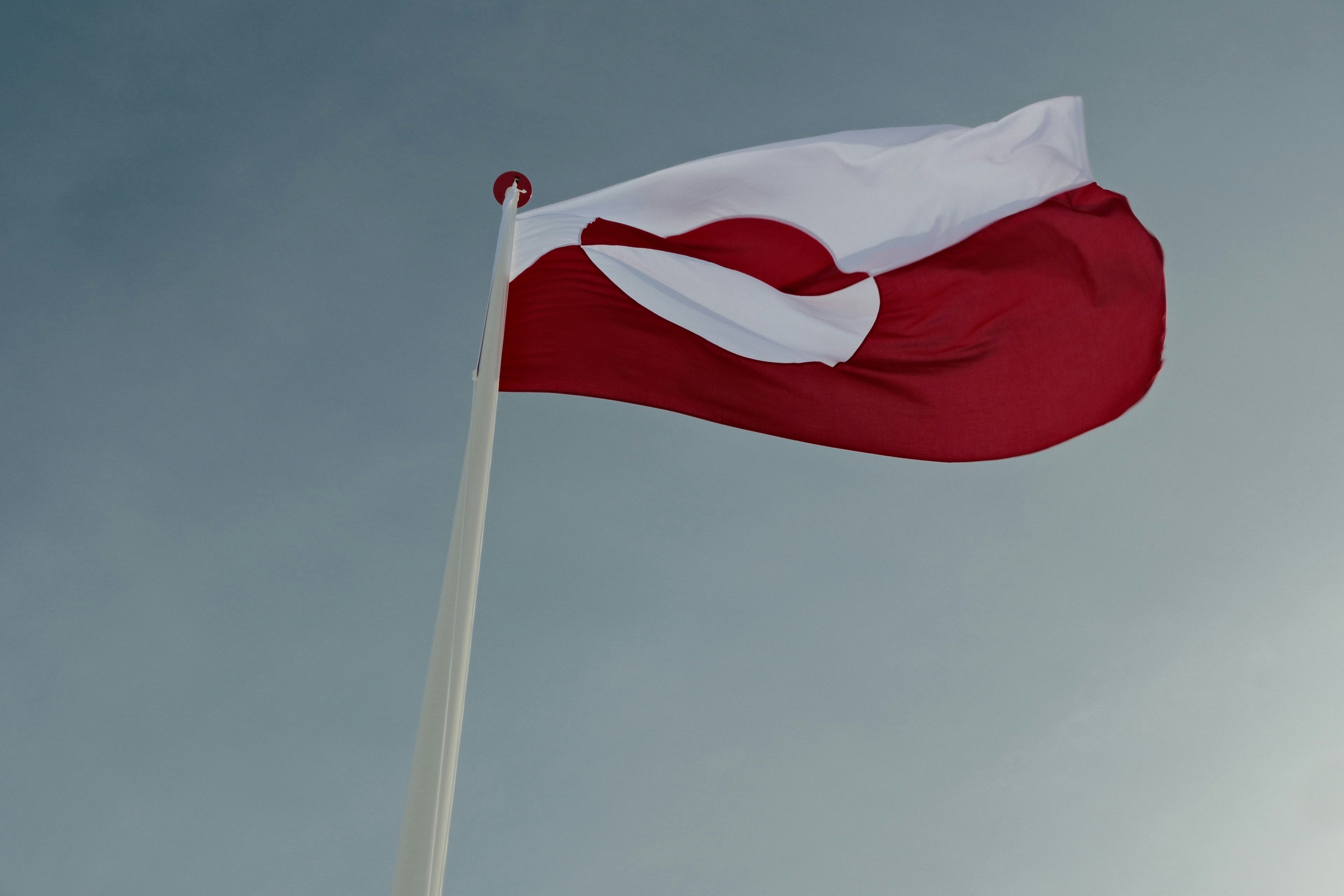 Bandeira da Groenlândia tremulando contra um céu nublado