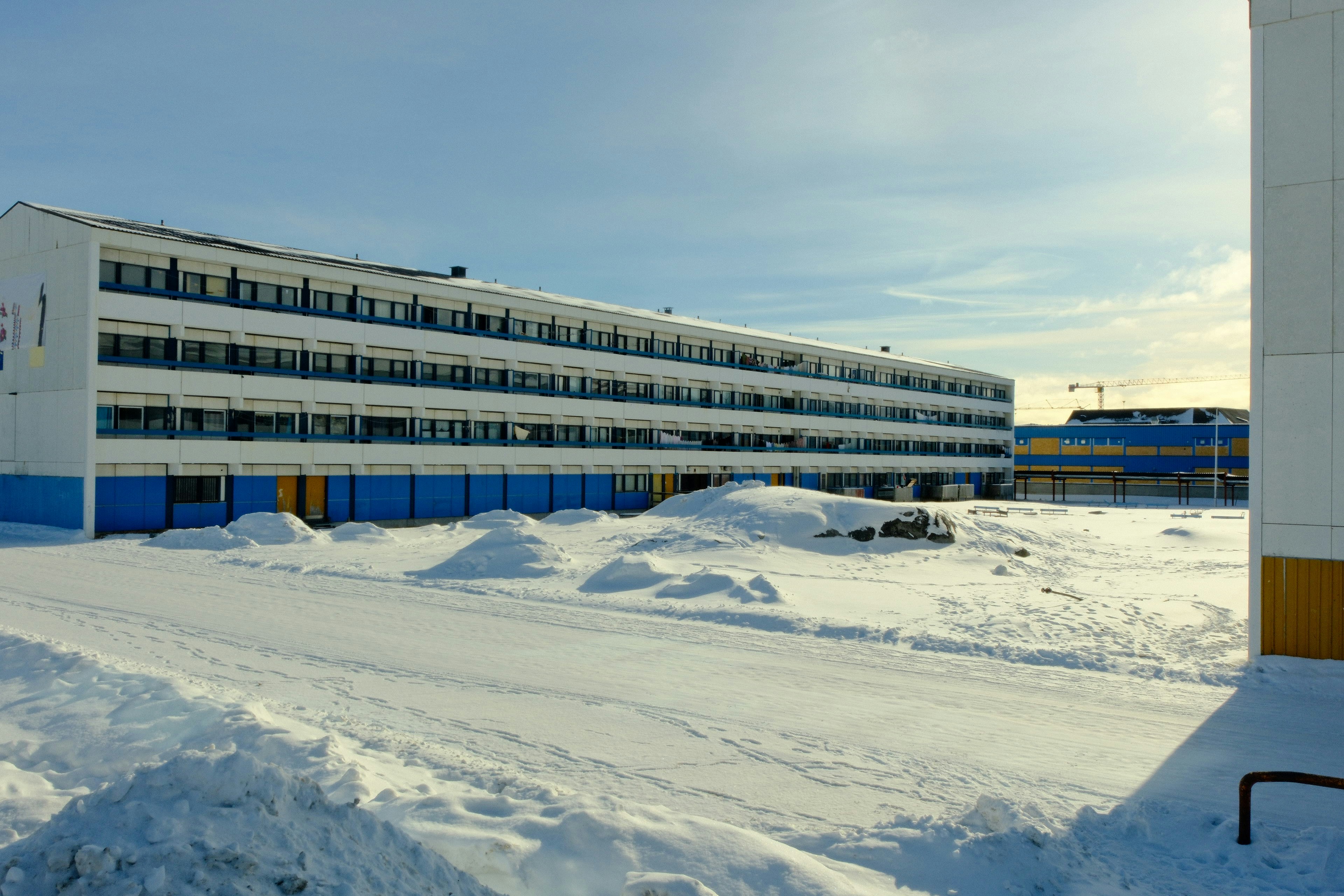 Um prédio moderno coberto de neve sob um céu limpo