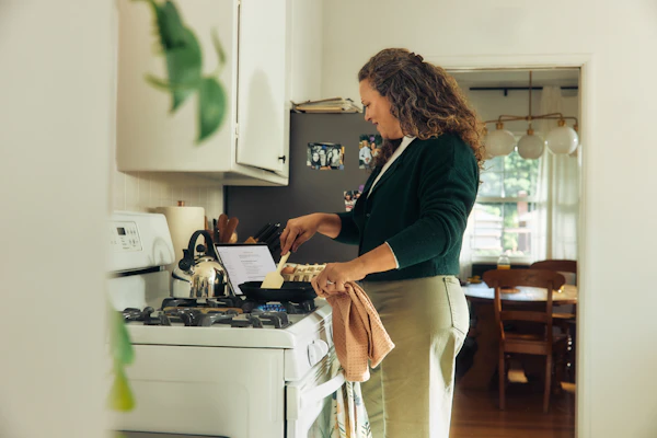 Femme qui cuisine sur une cuisinière dans une cuisine