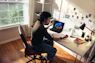 Person working at a desk with a laptop and books.