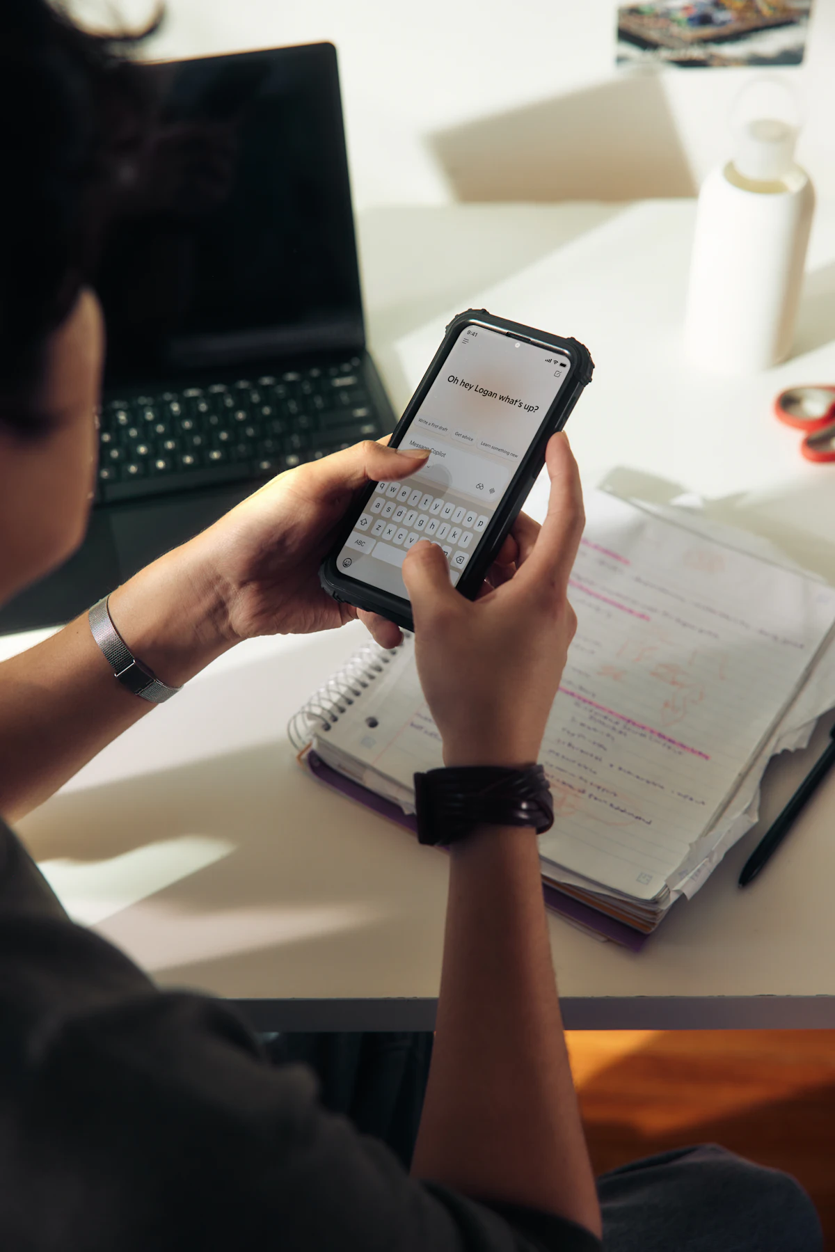 Personne utilisant un smartphone au-dessus d'un cahier