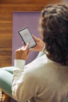 Woman using a smartphone on a yoga mat.