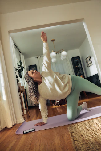 A woman does a yoga pose on a mat