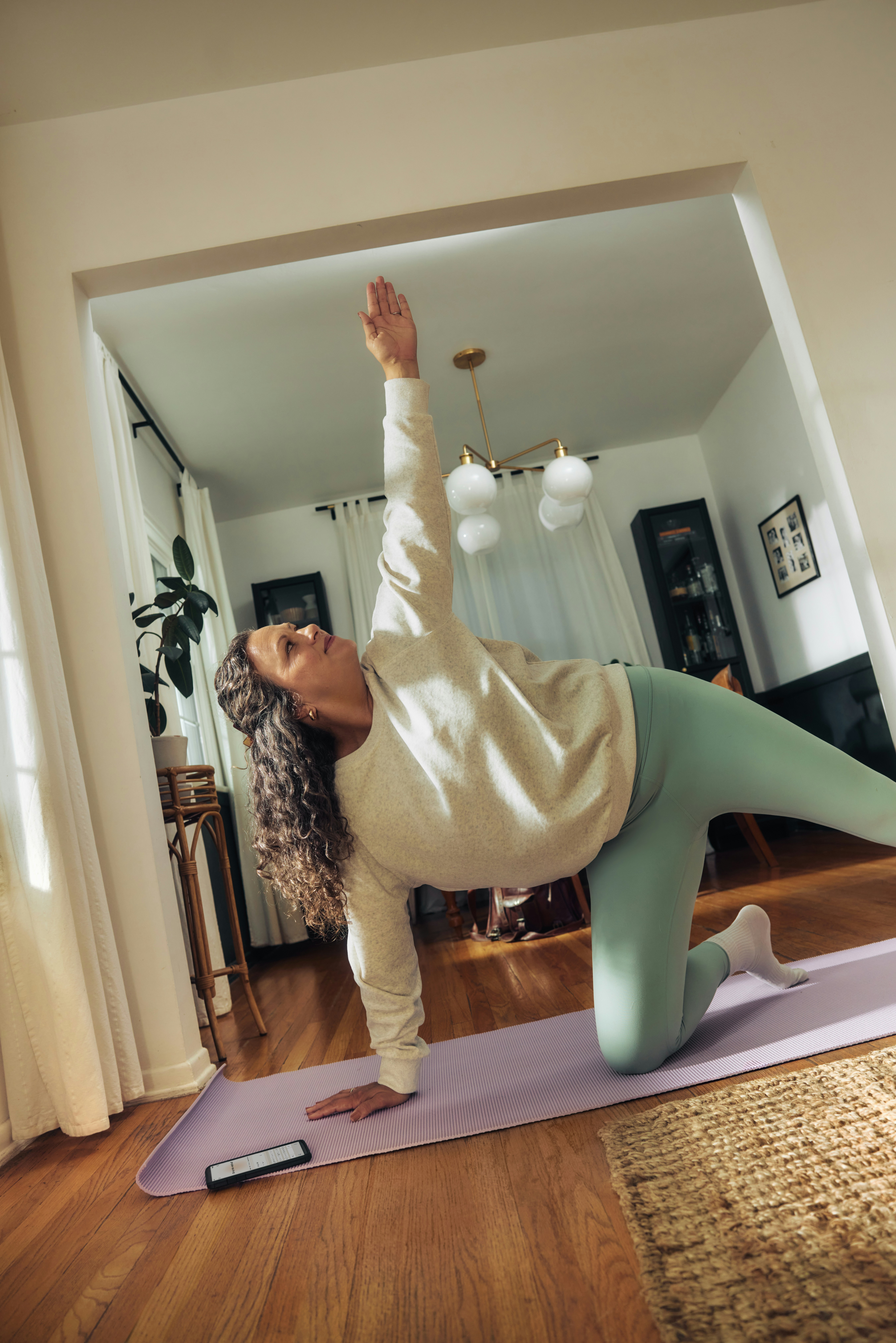 A woman does a yoga pose on a mat