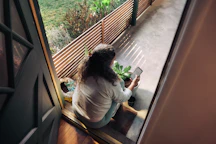 Woman sitting on balcony with smartphone