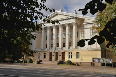 Grand building with large columns and trees